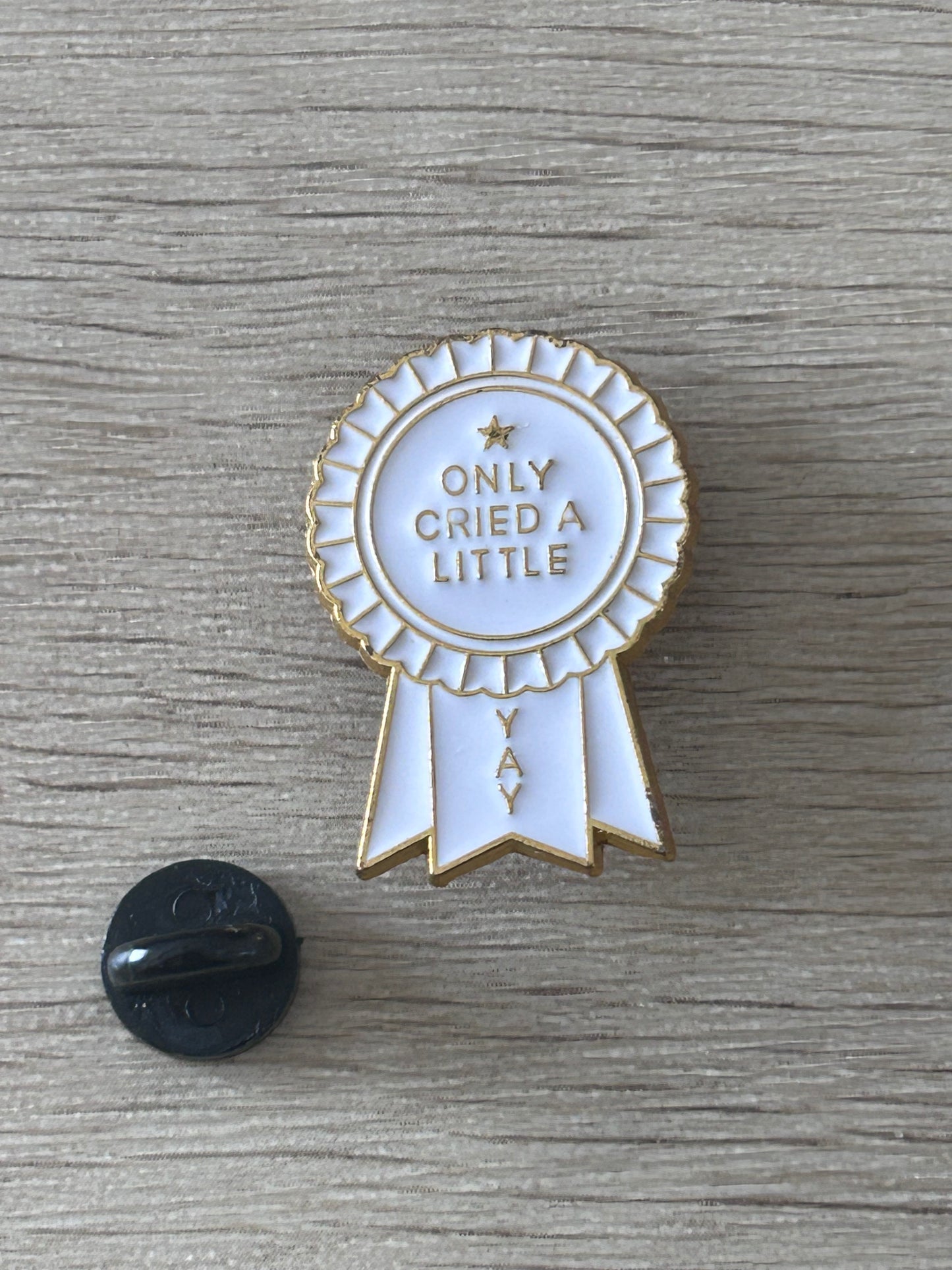 Épingle rosette blanche avec rubans, texte « ONLY CRIED A LITTLE » et dos noir