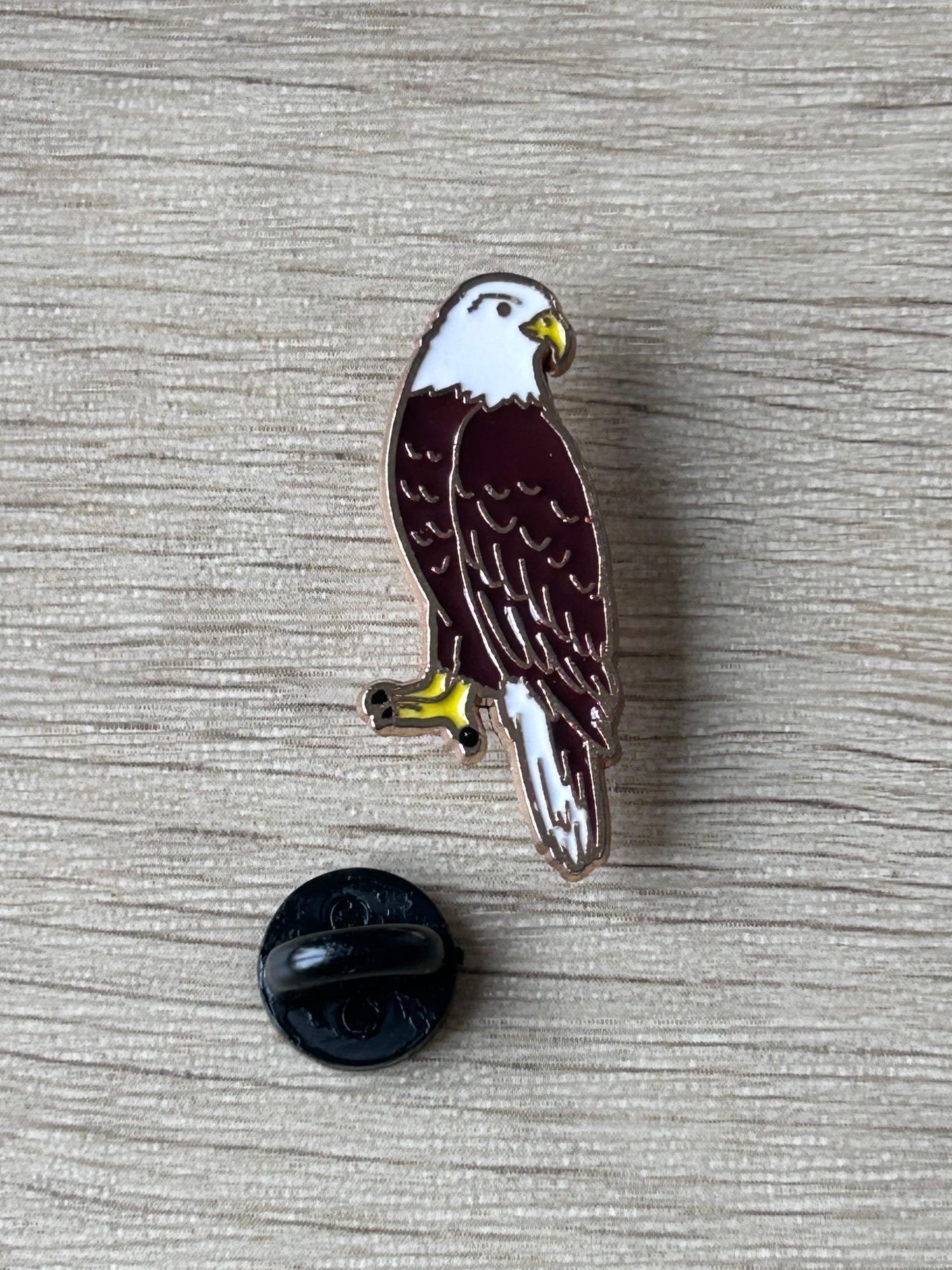 Pin en émail aigle noir et blanc, bec jaune, attache arrière noire visible