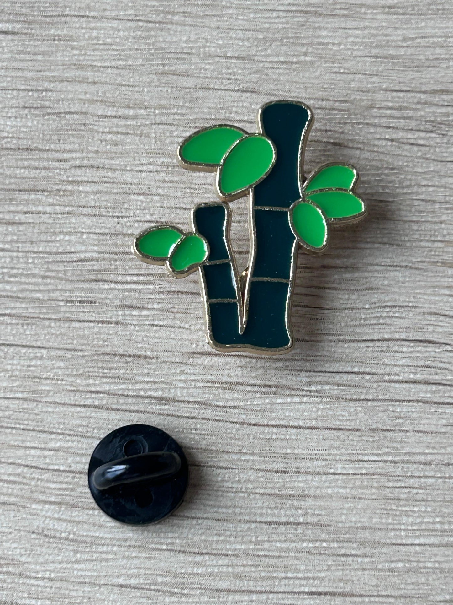 Broche en émail bambou vert avec feuilles, tige sombre, fond rond noir