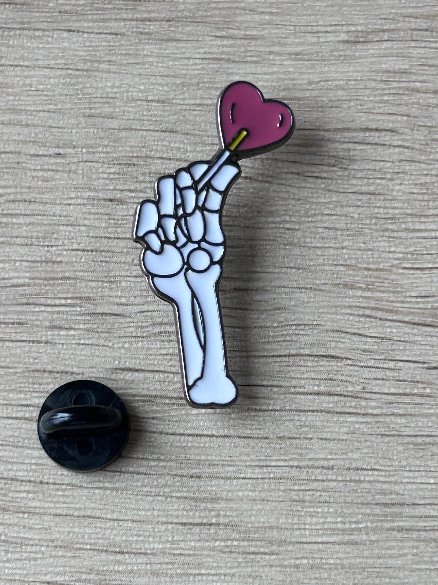 Épingle main squelettique avec cœur violet et attache noire