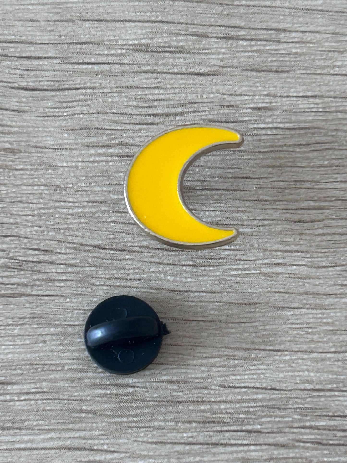 Broche croissant de lune jaune, épingle noire visible au dos