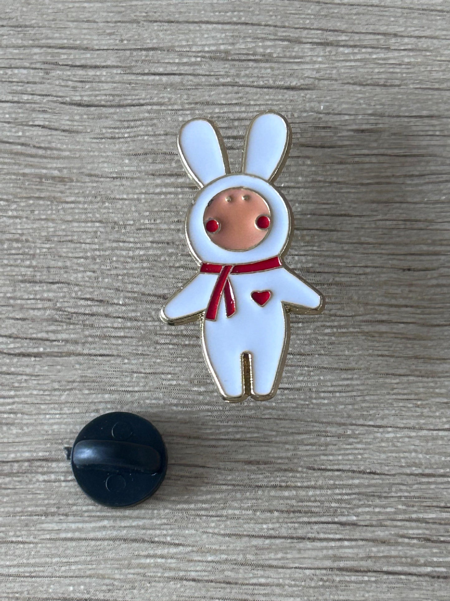 Épingle lapin costume bleu clair avec nœud rouge; attache noire visible
