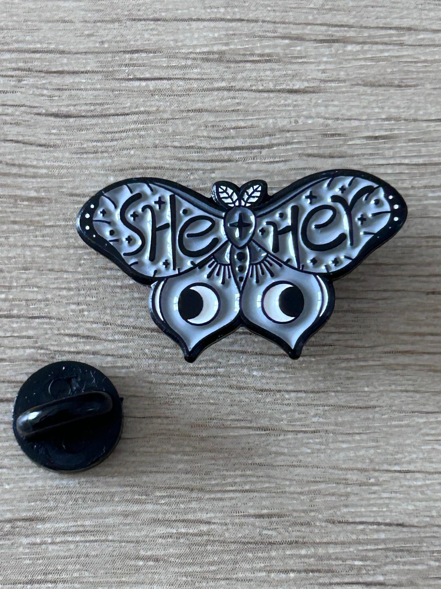 Broche papillon noire et argent avec détails gravés, dos d’épingle visible