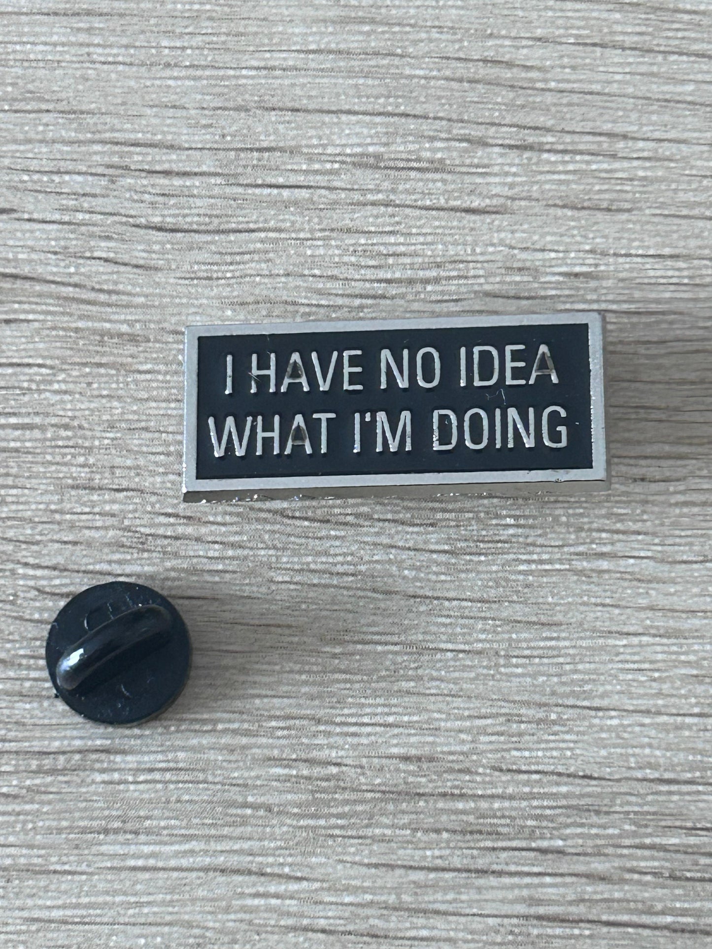 Épinglette noire rectangulaire avec texte « I HAVE NO IDEA WHAT I'M DOING »