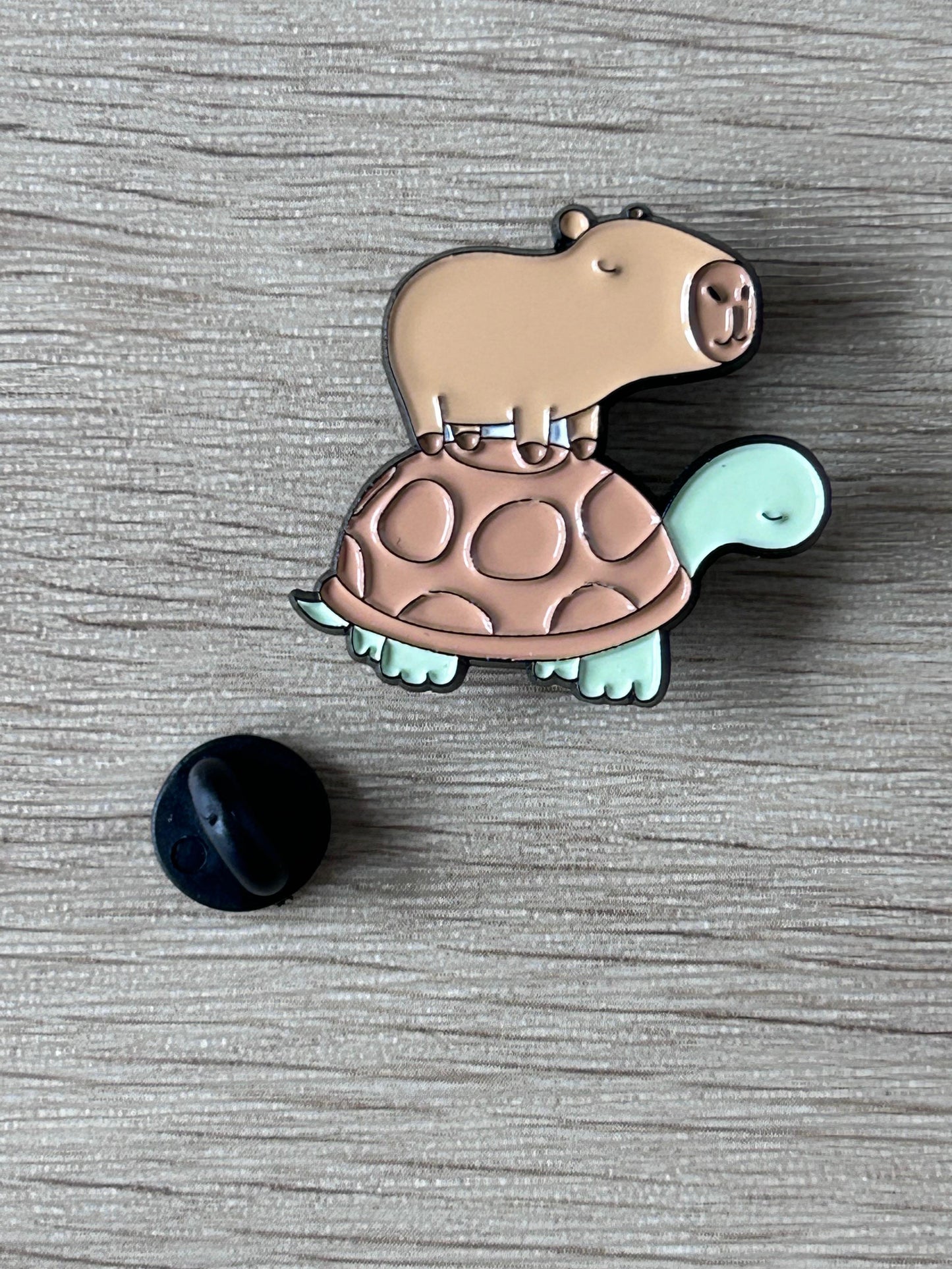 Broche émaillée capybara sur tortue, beige, coque menthe, fermoir noir visible