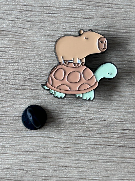 Broche émaillée capybara sur tortue, beige, coque menthe, fermoir noir visible