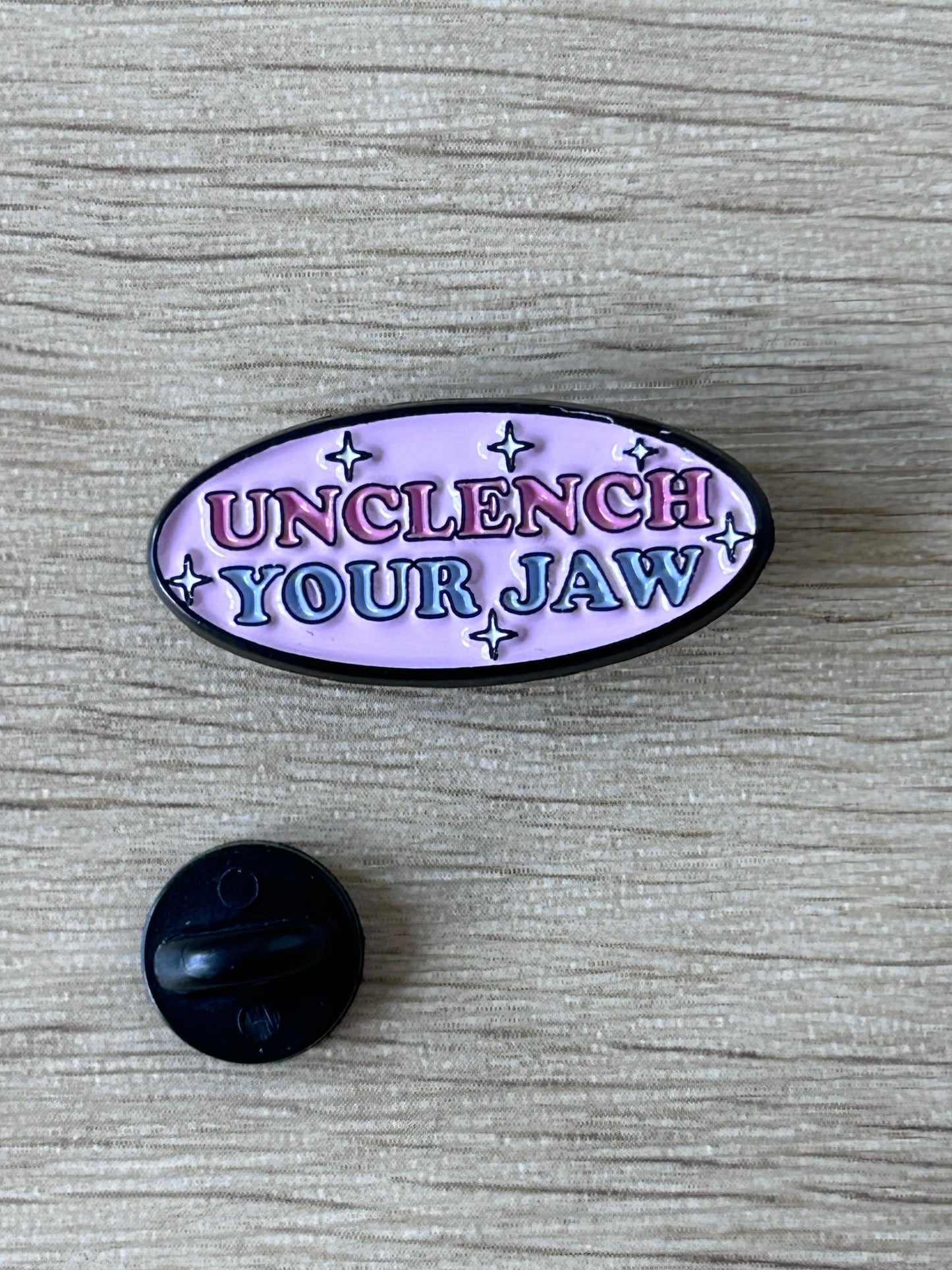 Pin ovale émaillé violet « Unclench Your Jaw » et petit support noir