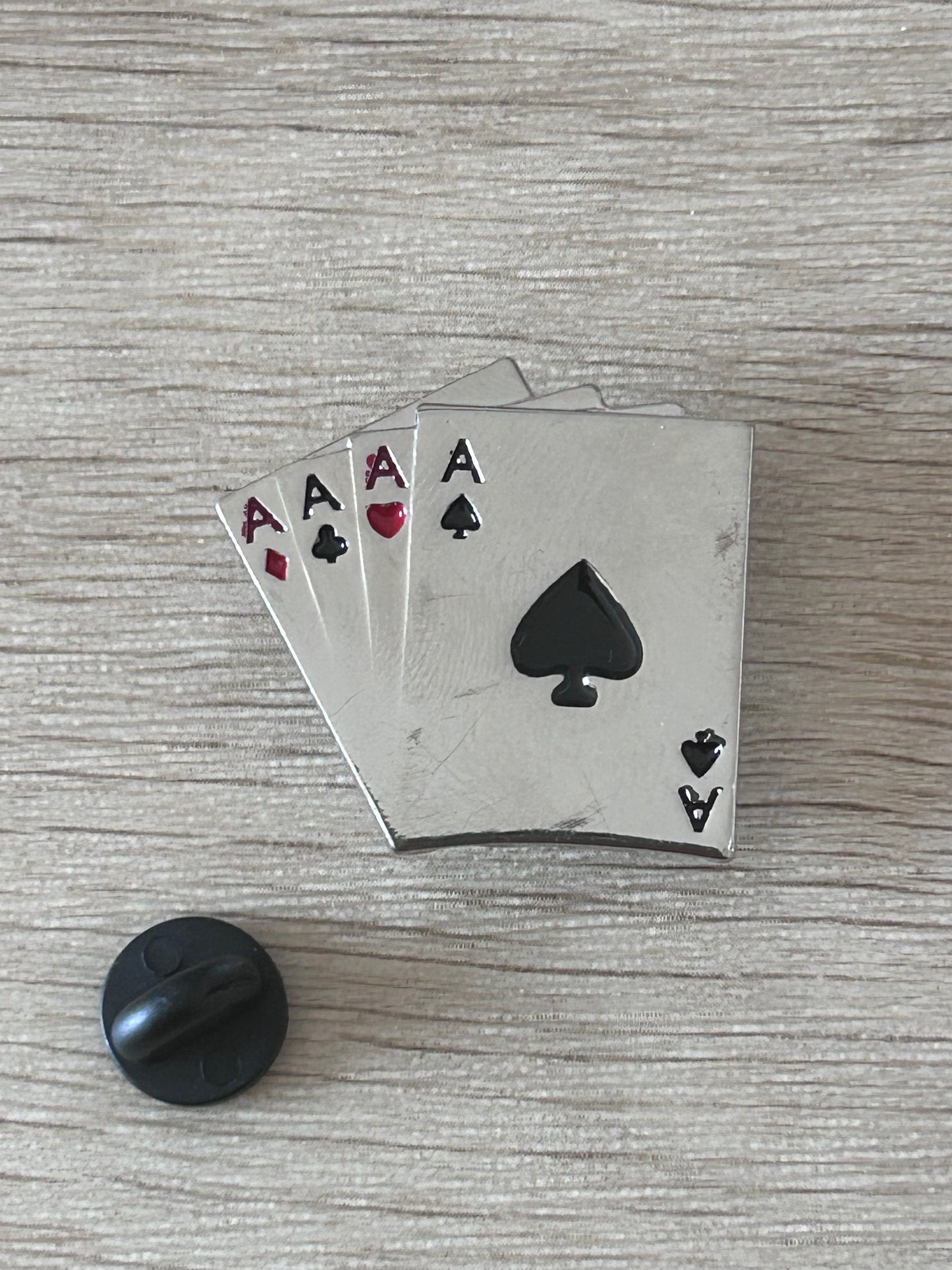 Détail d’un pin's carré d’as avec as de cœur, de pique, de carreau et de trèfle
