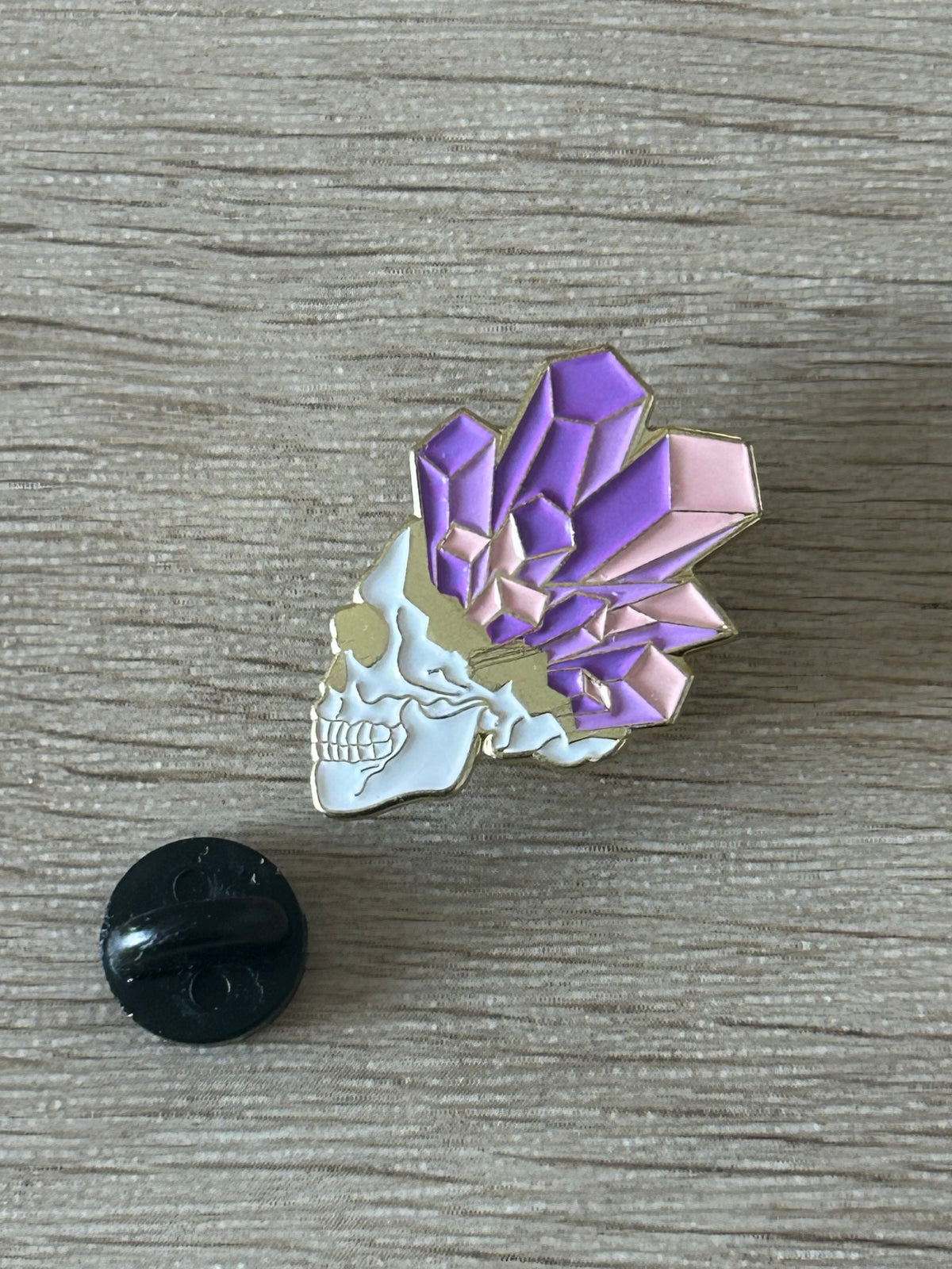 Pin's représentant un crâne orné de cristaux violets