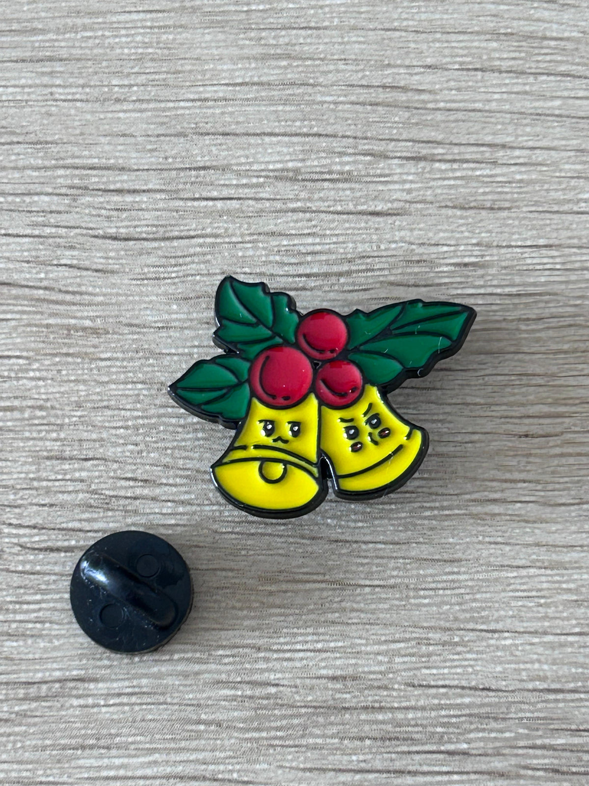 Pin's cloches de Noël kawaii avec dos noir : deux clochettes jaunes et décor vert rouge.
