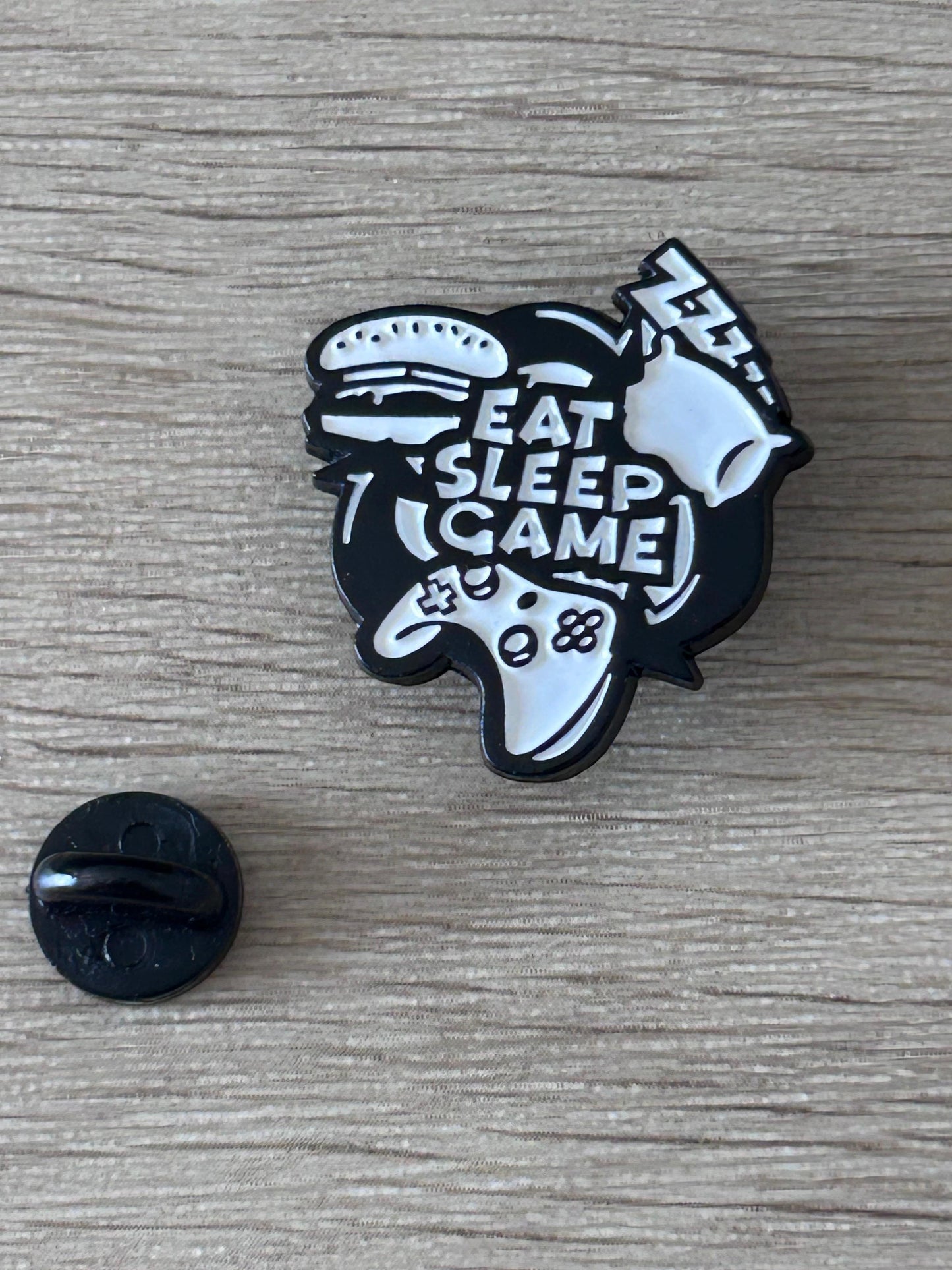 Pin's Eat Sleep Game vue de face, émail noir et blanc contour noir mat
