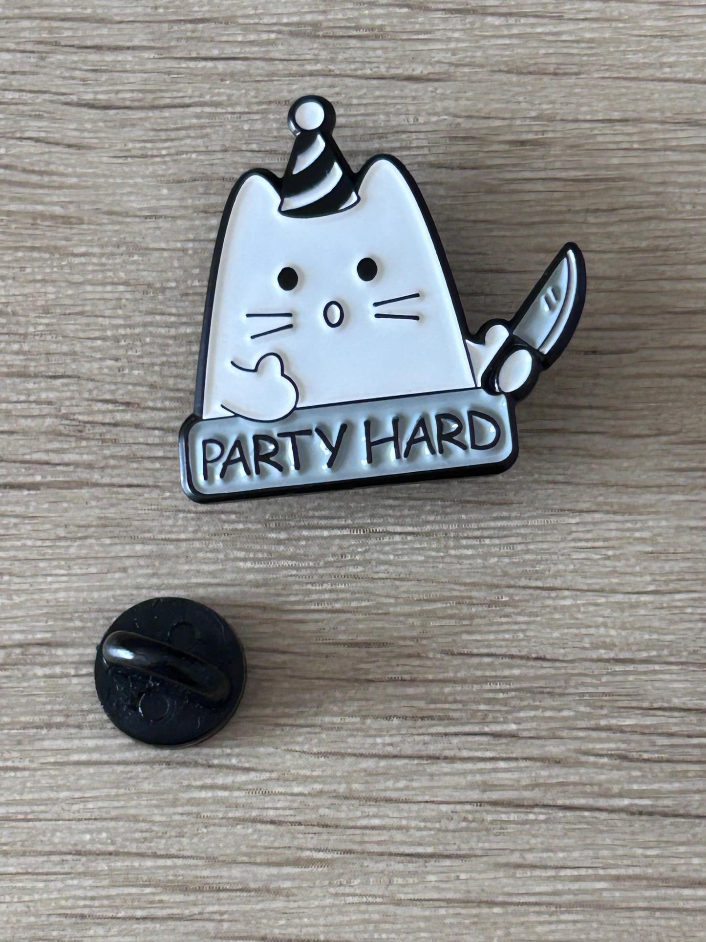 Broche émaillée chat blanc, texte « PARTY HARD », dos noir visible
