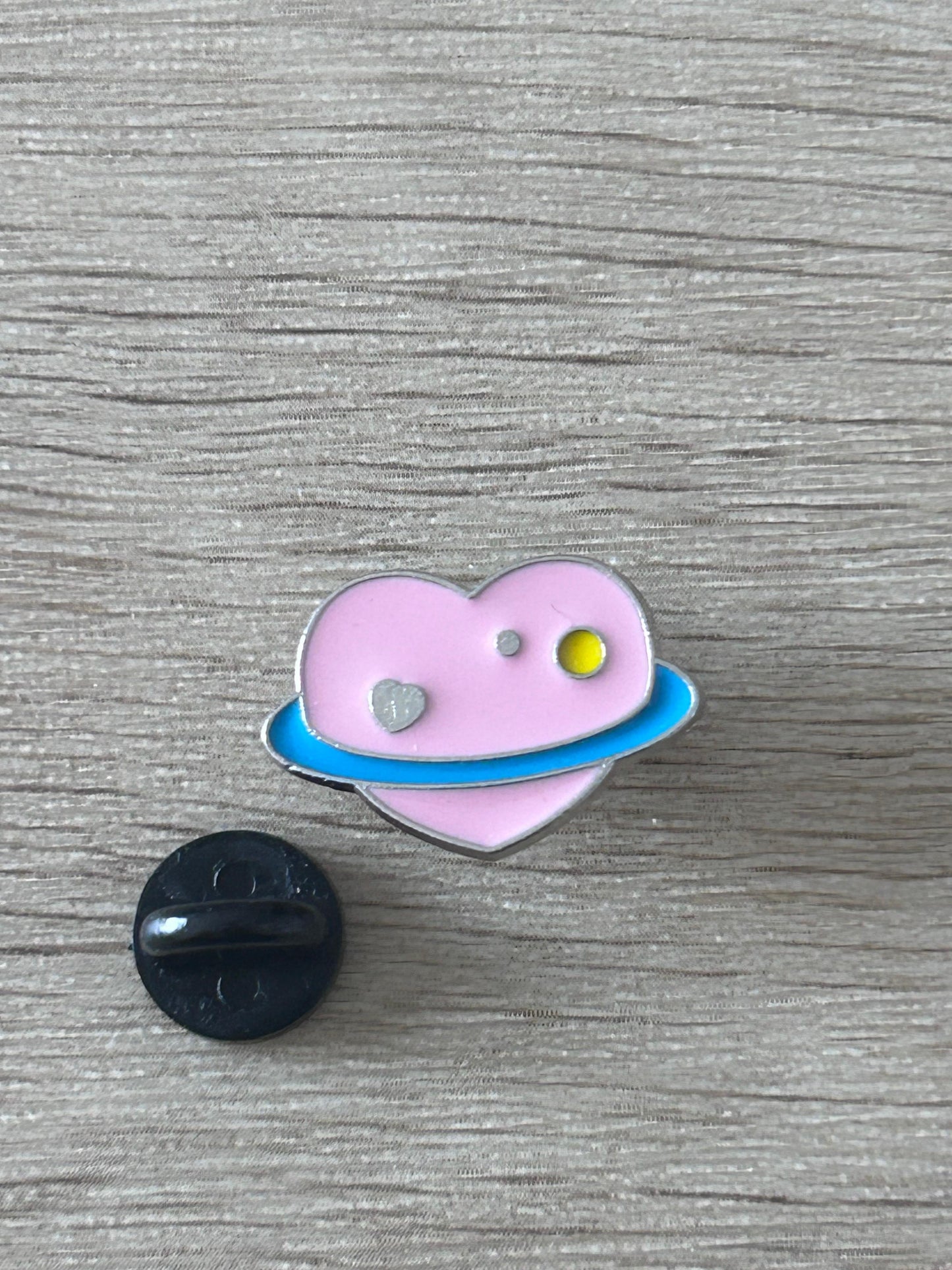Épingle cœur planète violette avec petit disque argenté et motif ovale bleu