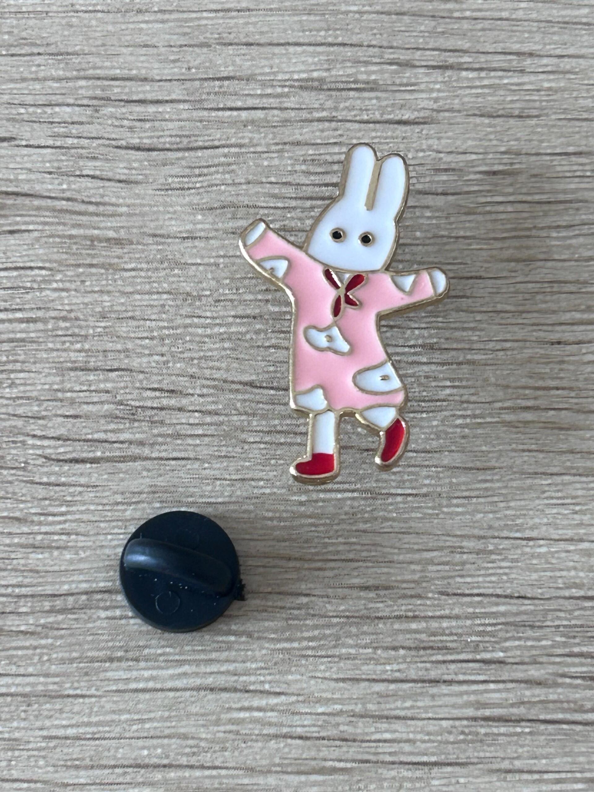 Pin's lapin danseur en robe rose, dos noir rond visible