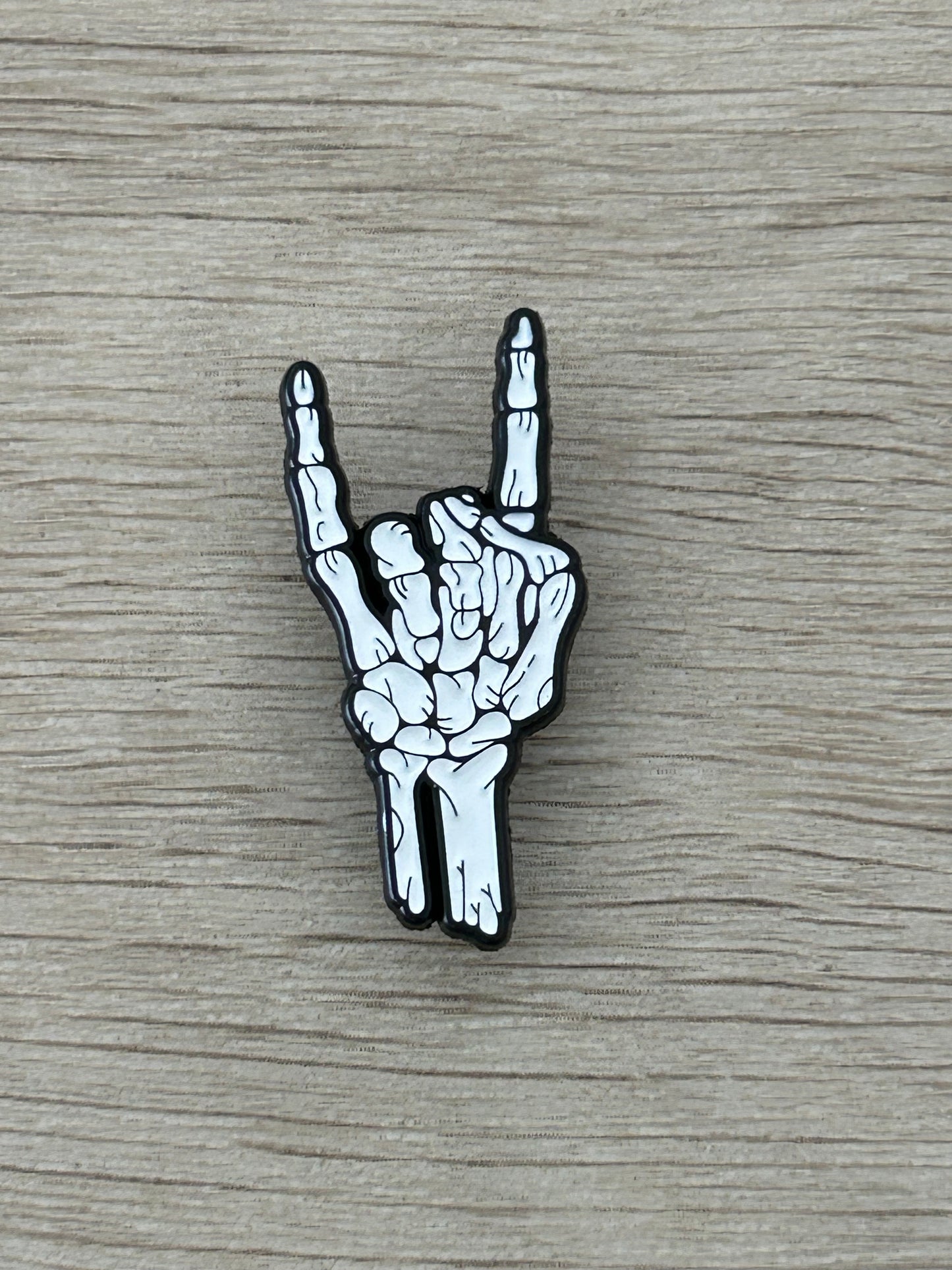 Broche émaillée main squelette signe rock, noir et blanc