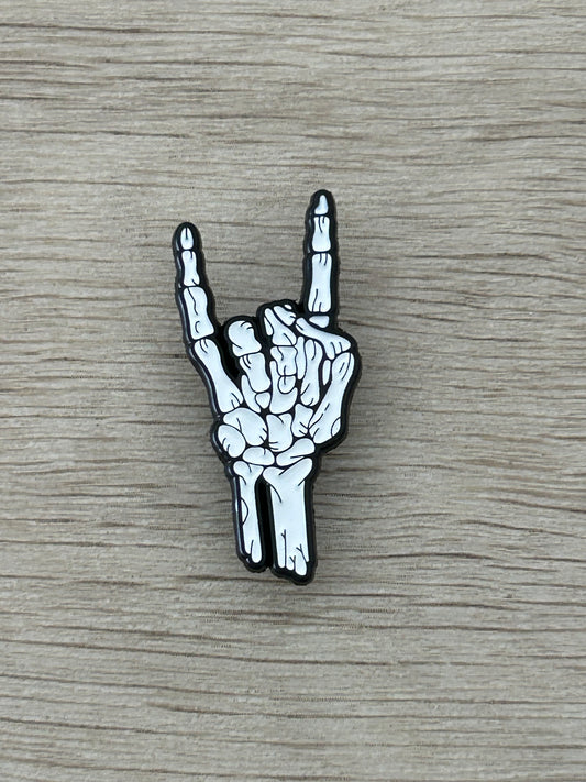 Broche émaillée main squelette signe rock, noir et blanc
