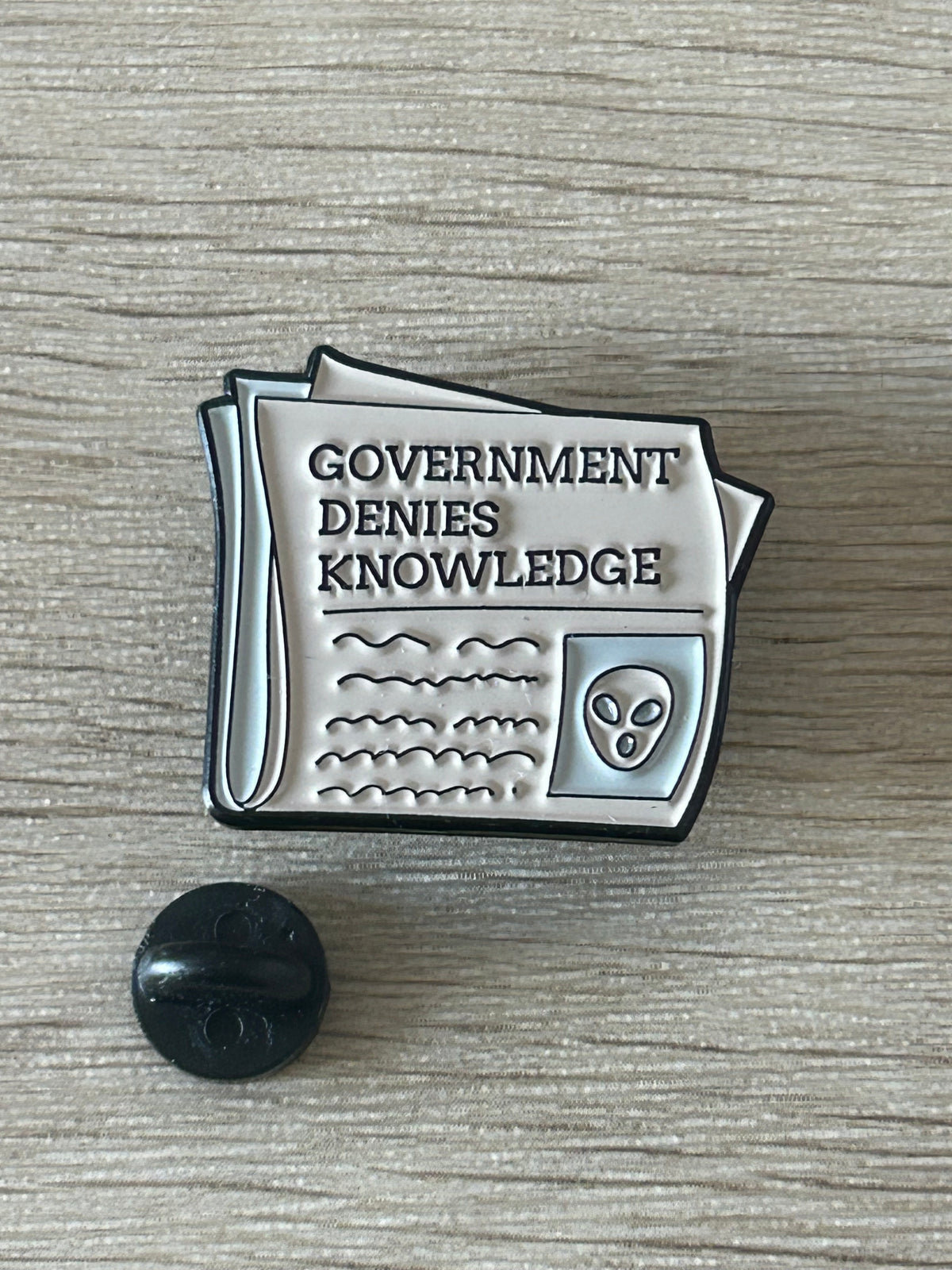 Pin's journal avec le message Government denies knowledge et un symbole alien