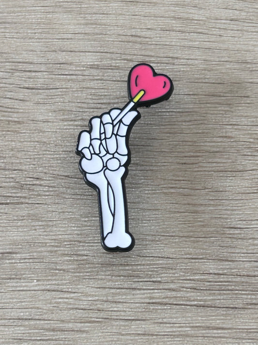 Pin en forme de main de squelette avec cœur rose et détail jaune