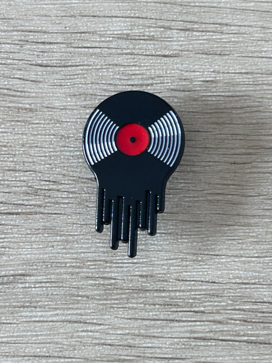 Broche vinyle qui semble  fondre, rayures argentées et centre rouge