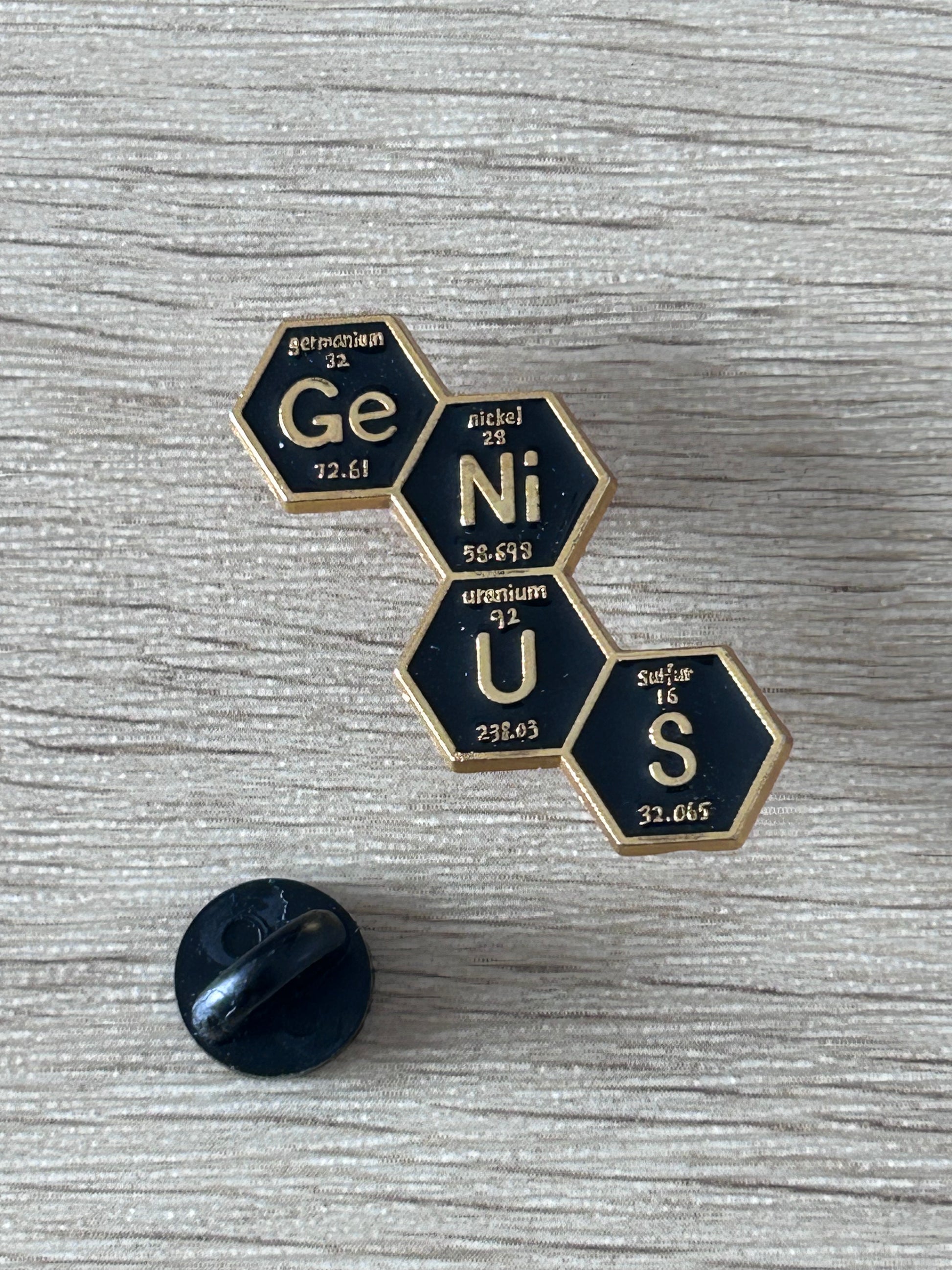 Épingle tableau périodique en hexagones Ge, Ni, U, S et capuchon noir