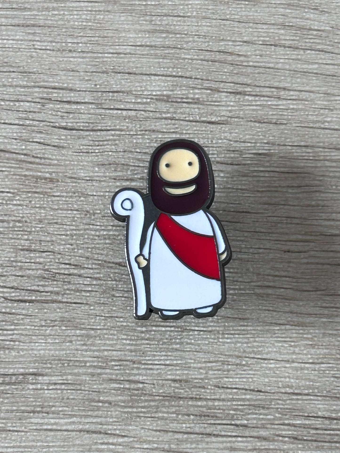 Pin Jésus kawaii, robe blanche et cape rouge, main levée, auréole sombre