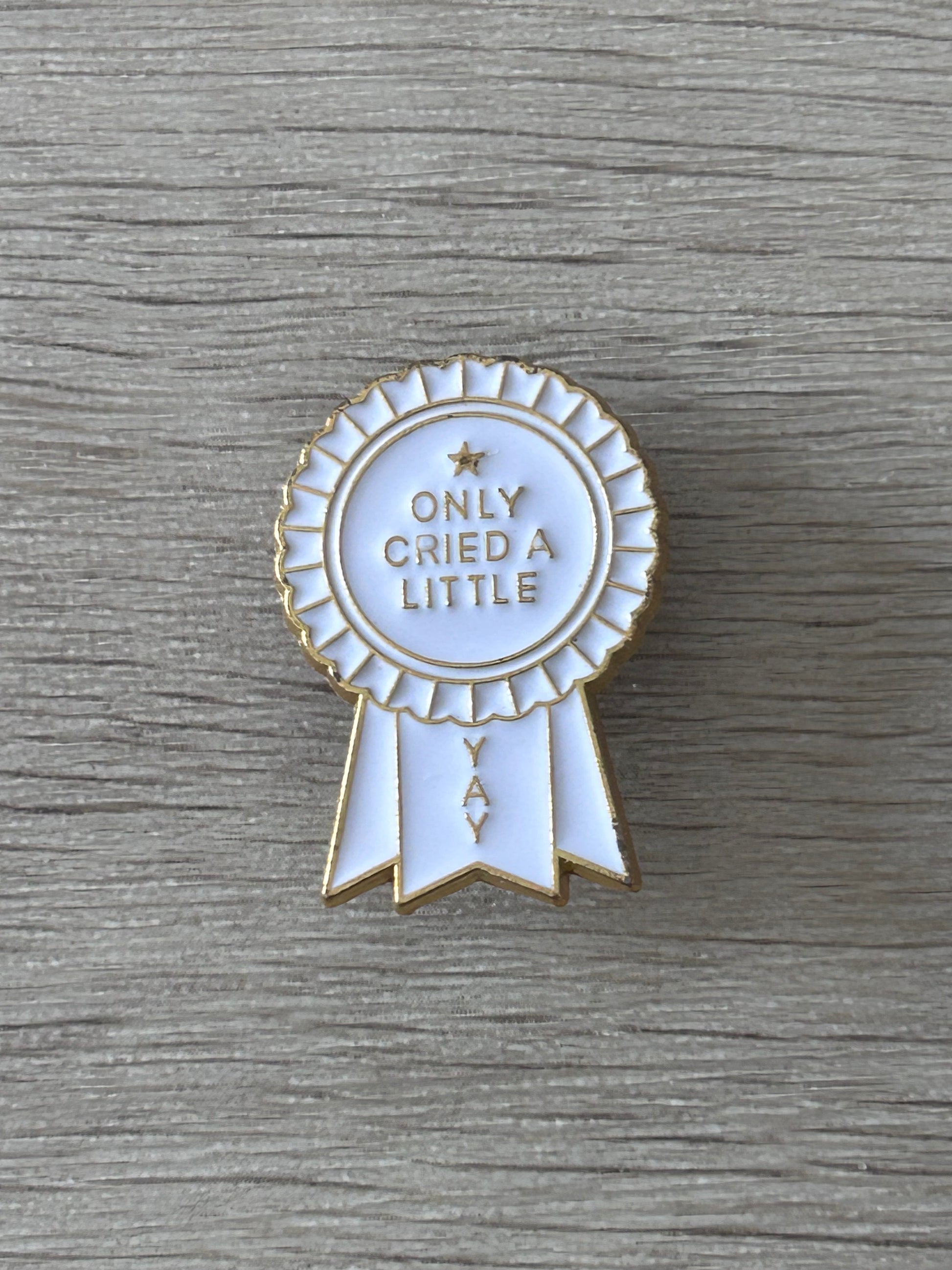 Épingle rosette blanche avec rubans, texte « ONLY CRIED A LITTLE »