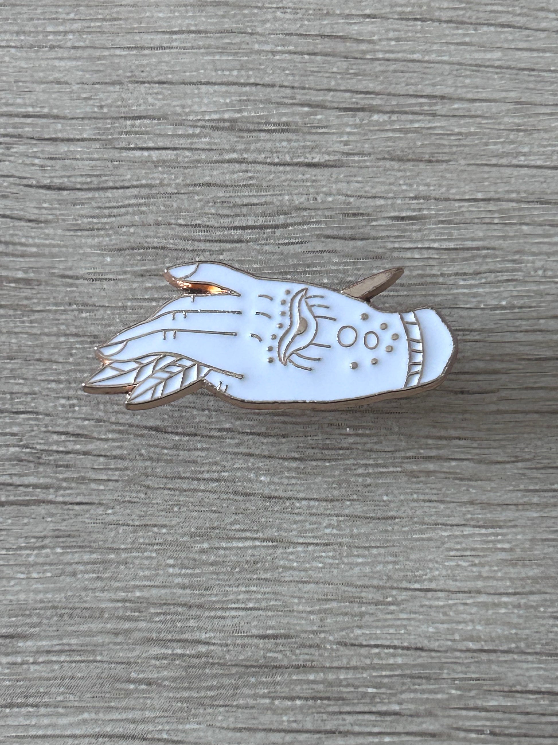 Épinglette en métal en forme de poisson blanc et doré, motifs bleus et œil stylisé