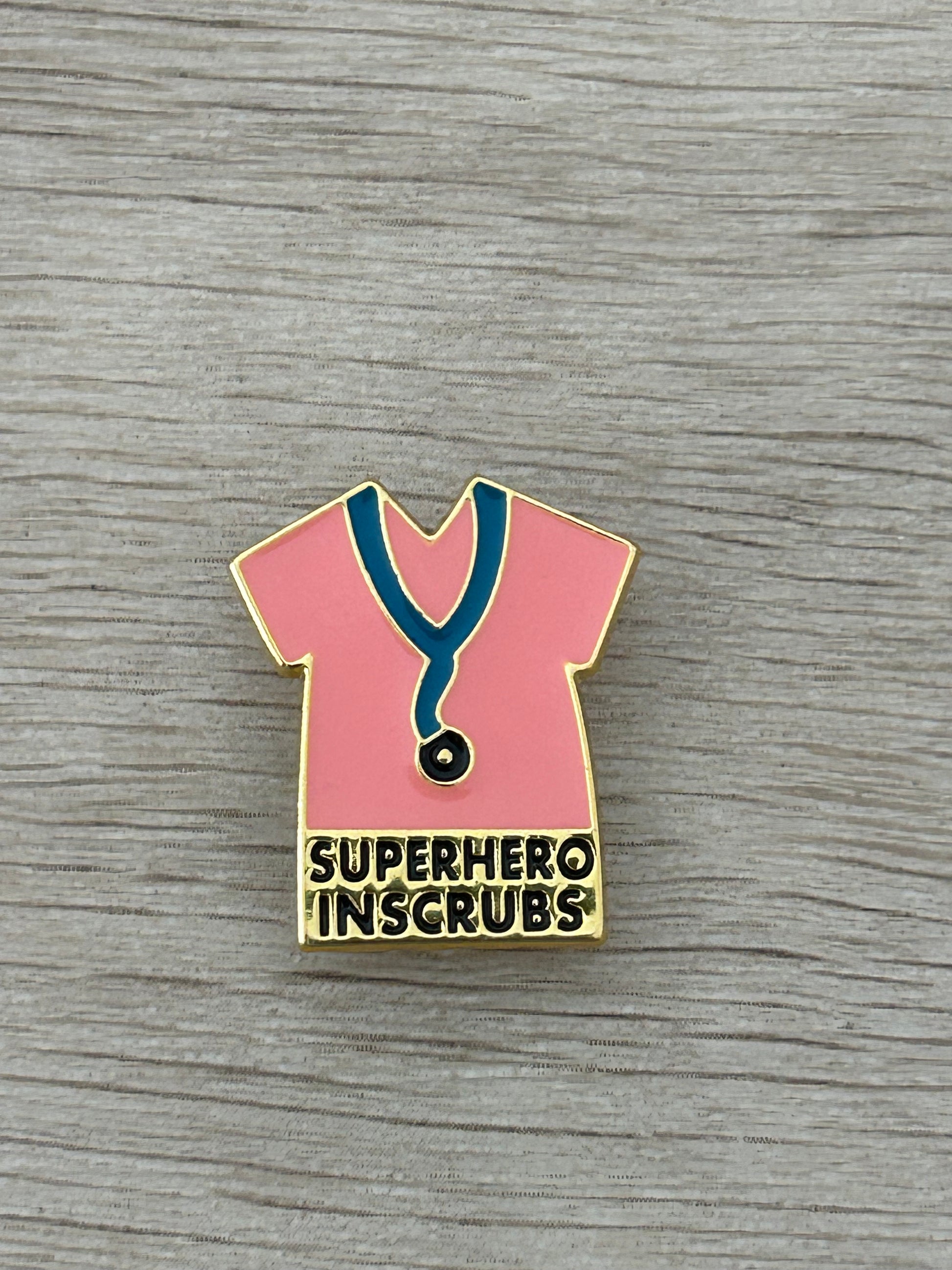 Épinglette broche de blouse rose super-héros, col vert, stéthoscope et texte « SUPERHERO INSCRUBS »