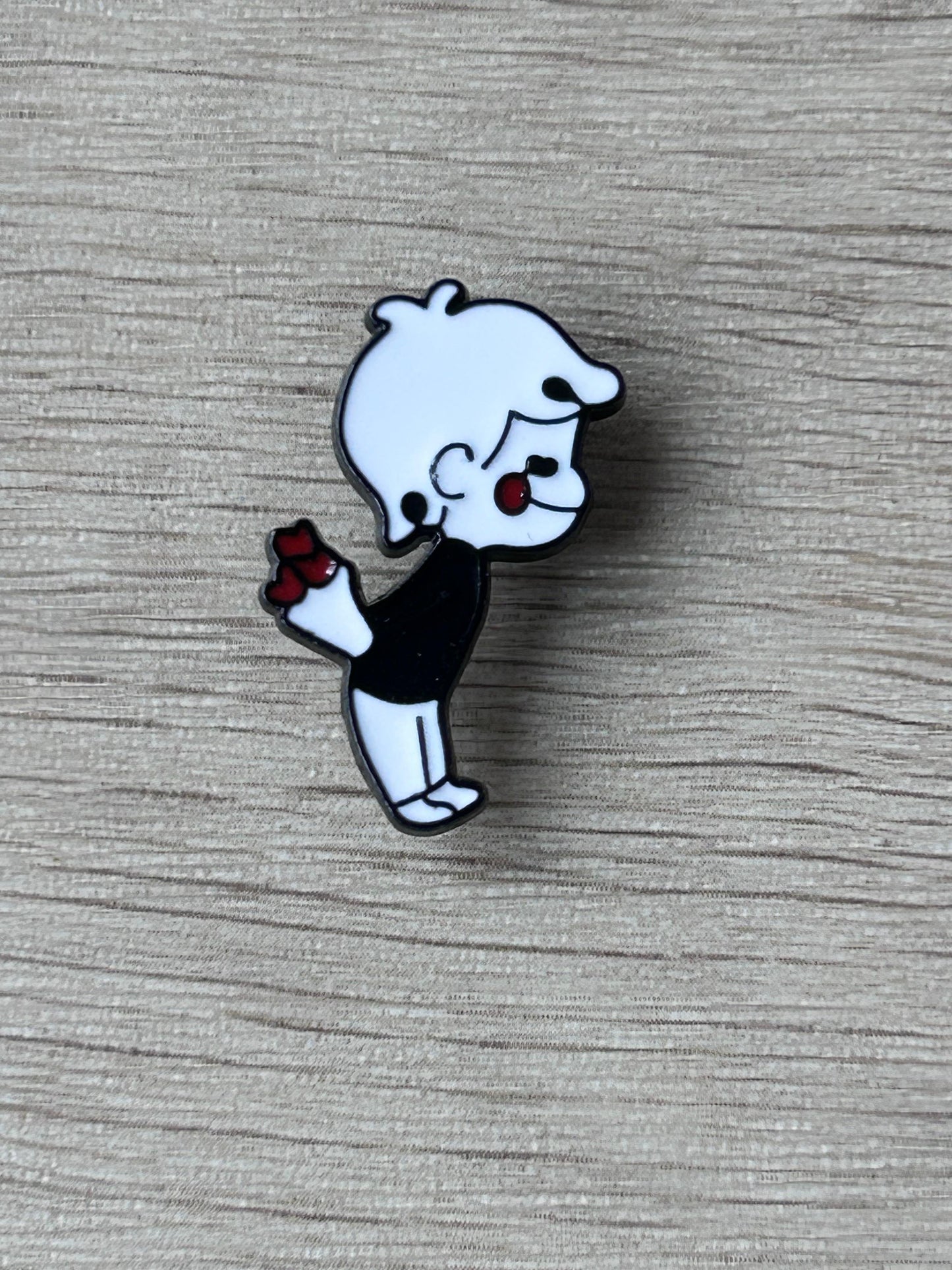 Pin's petit garçon cartoon noir et blanc tenant un bouquet de fleurs rouges