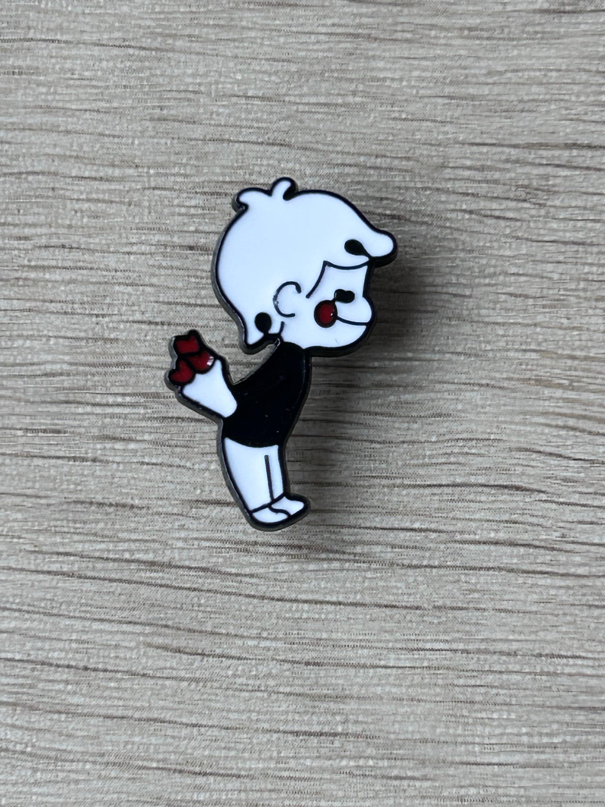 Pin's petit garçon cartoon noir et blanc tenant un bouquet de fleurs rouges