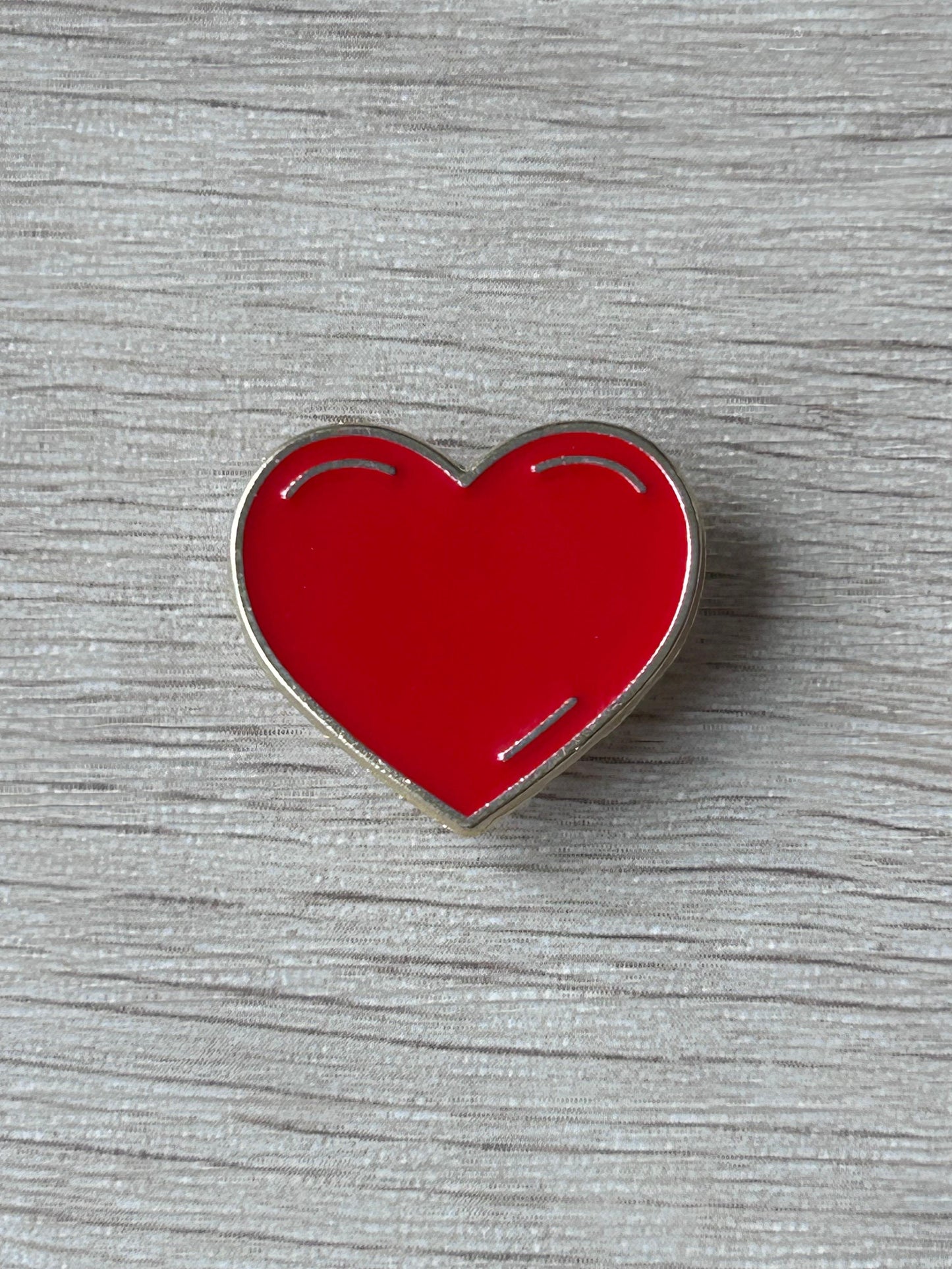 Pin's cœur rouge émaillé brillant avec contours argentés,