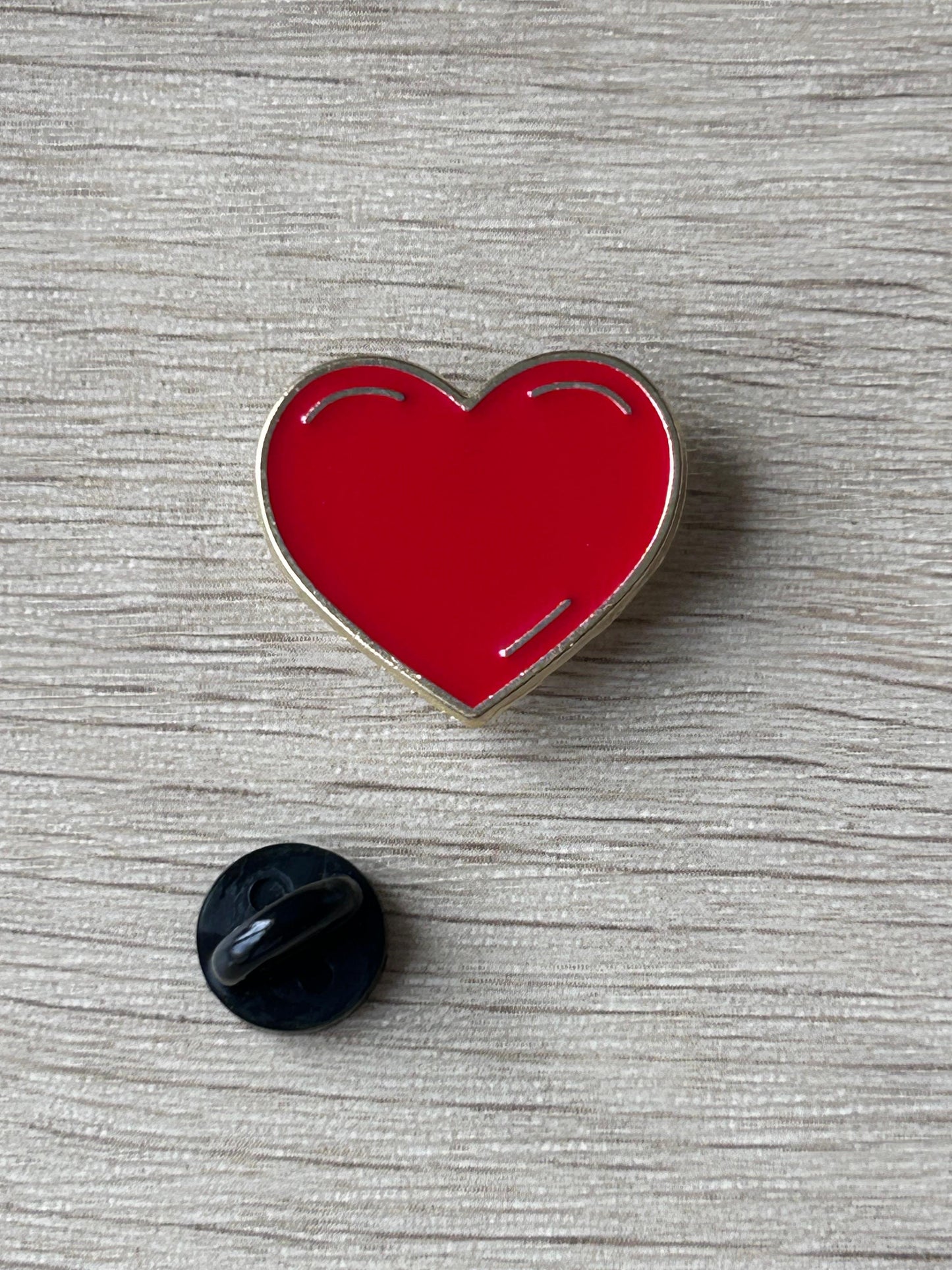 Pin's cœur rouge émaillé brillant avec contours argentés, avec attache en plastique noir