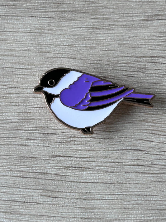Pin's en forme de mésange, corps noir et blanc, aile violette, style émaillé