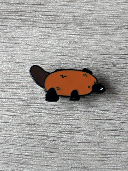 Pin's ornithorynque émaillé orange et noir, forme d’animal, avec fixation arrière.