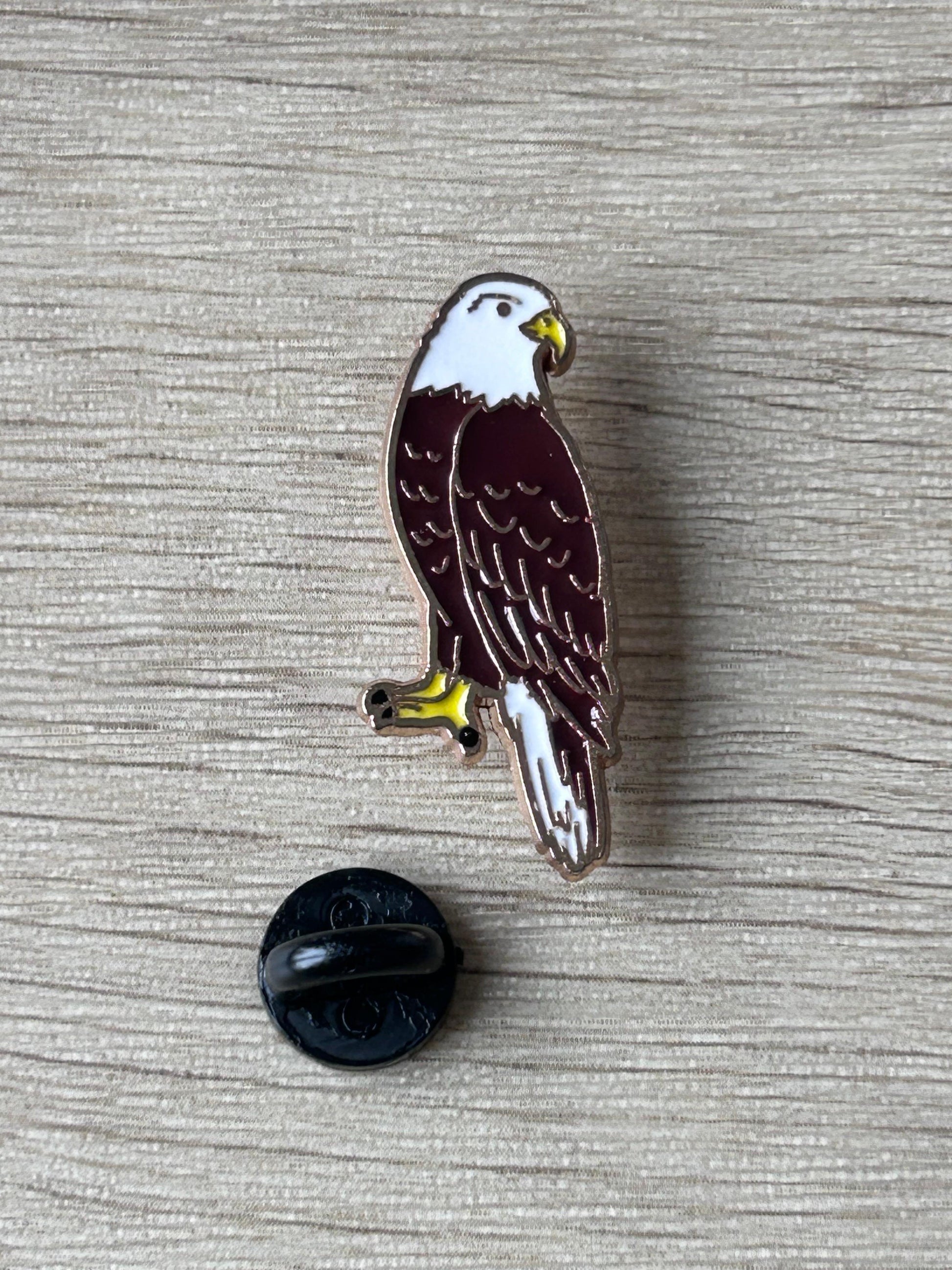 Pin en émail aigle noir et blanc, bec jaune, attache arrière noire visible