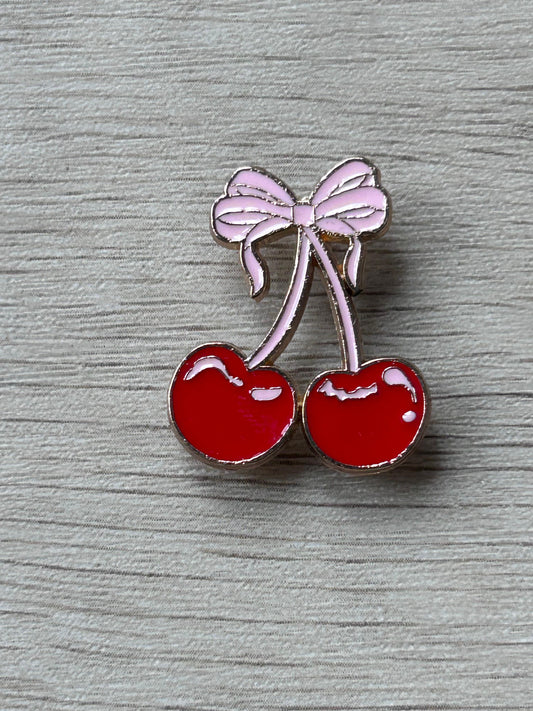 Pin en émail de deux cerises rouges avec nœud rose