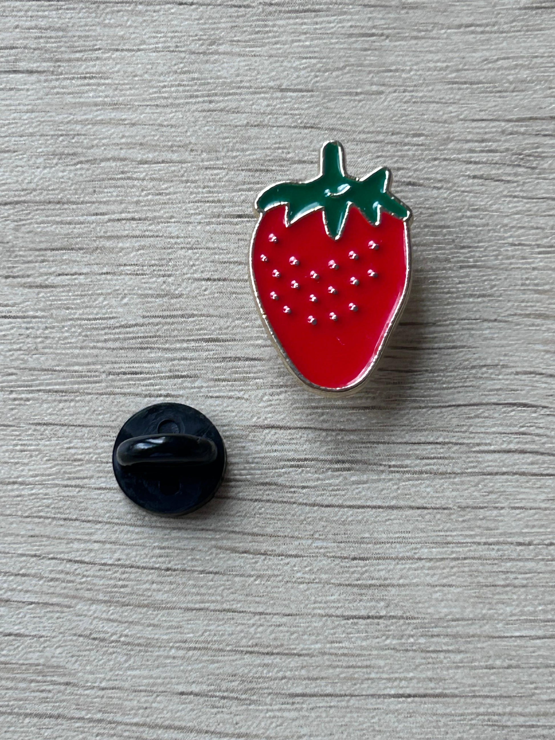 Pin fraise émaillée rouge avec feuillage vert et dos noir