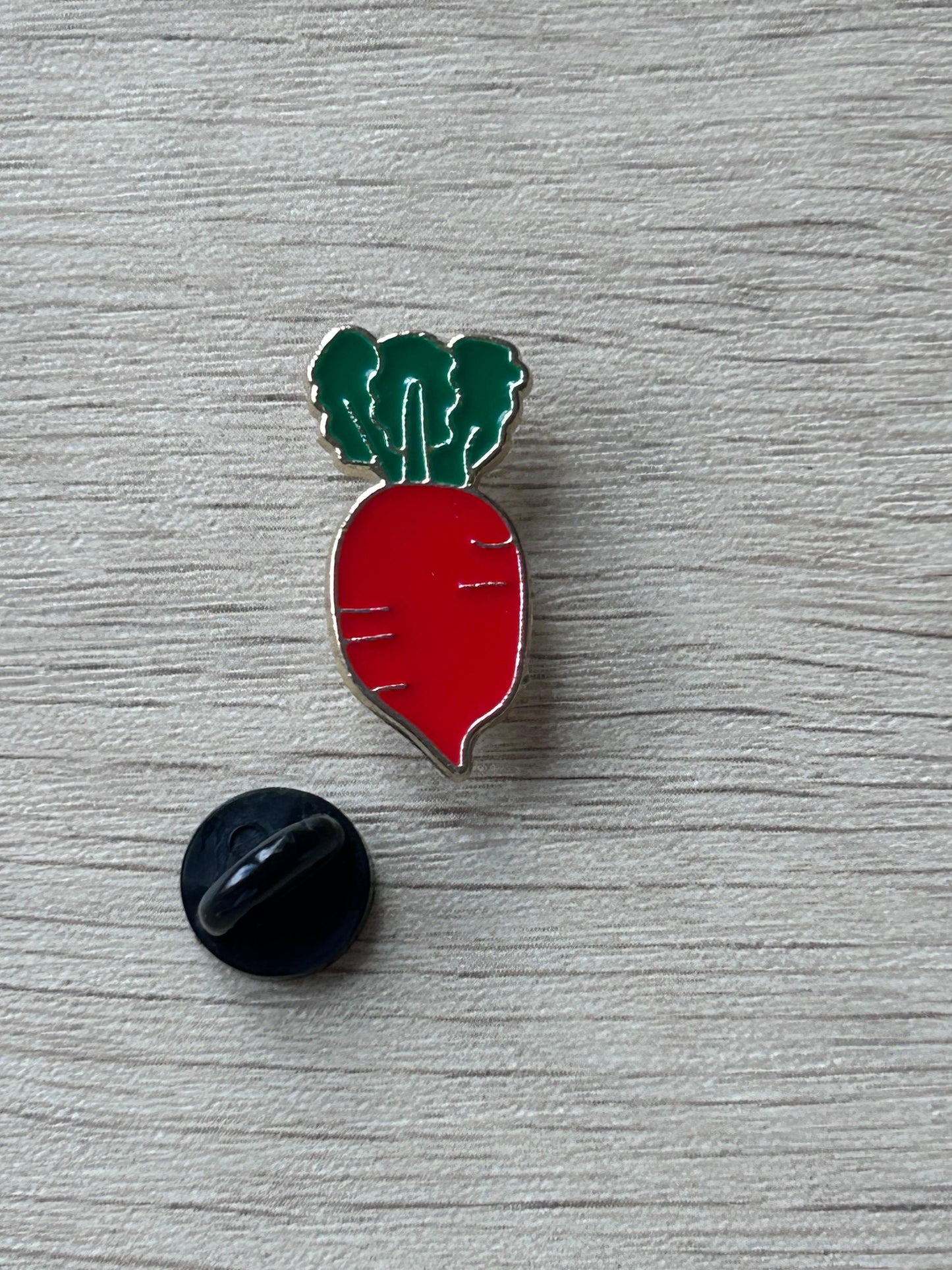 Pin's émaillé en forme de radis rouge, tige verte