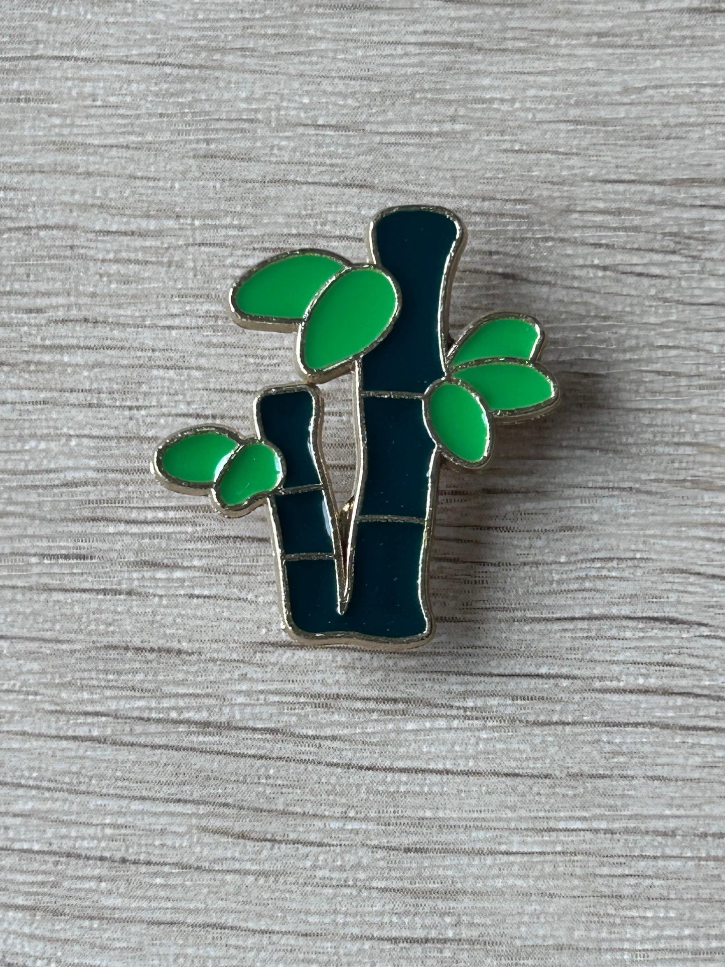 Broche bambou émaillée : tiges sombres et feuilles vertes découpées