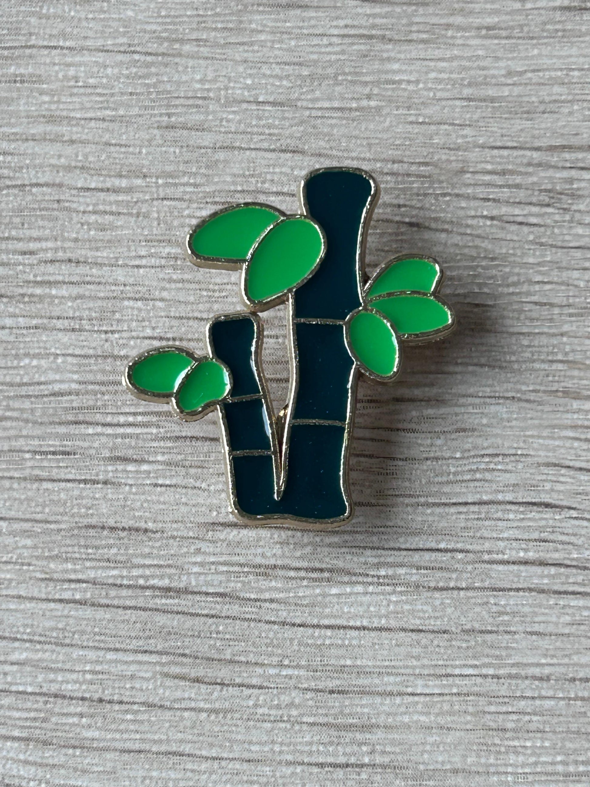 Broche bambou émaillée : tiges sombres et feuilles vertes découpées