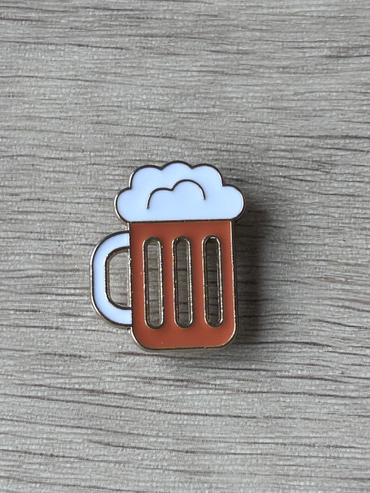 Pin's chope de bière: mousse blanche, corps brun à trois barres, contour argenté.