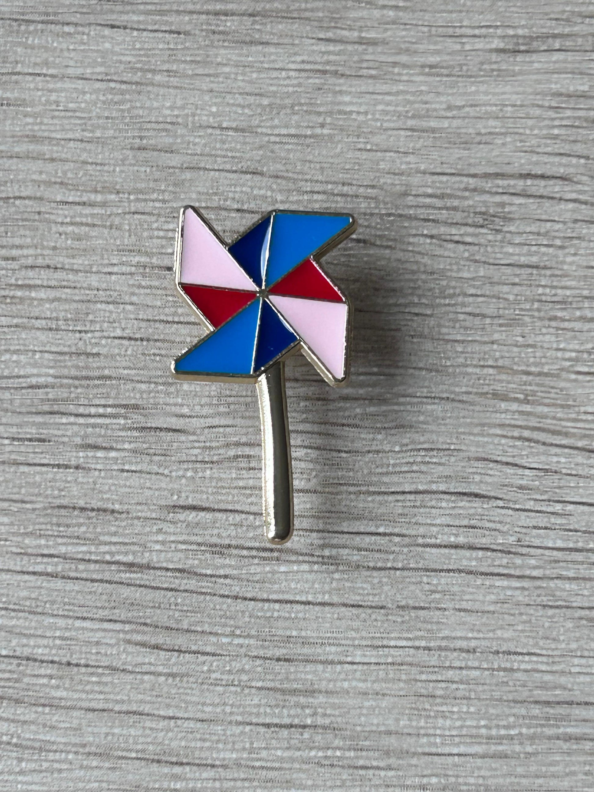 Pin's moulin à vent multicolore avec tige métallique, émaux bleu, rouge et rose