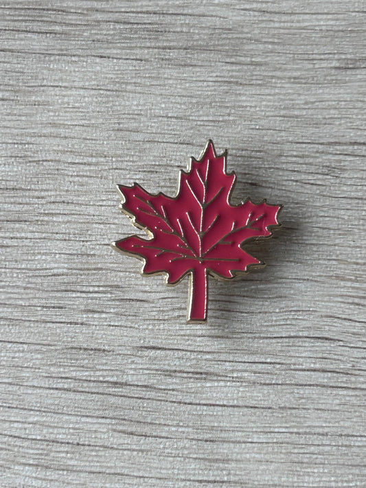 Broche feuille d’érable rouge émaillée, bord argenté et tige verticale.