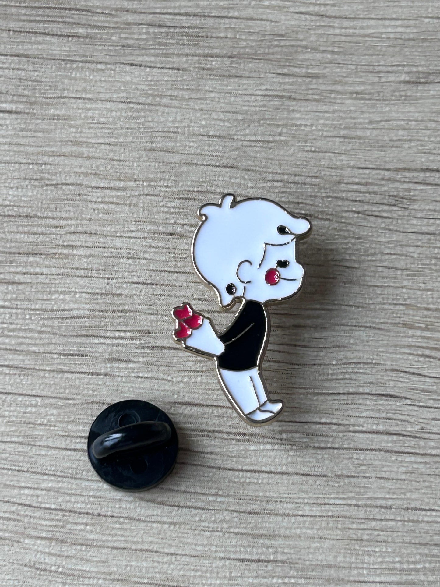Broche émail garçon kawaii tenant un petit bouquet rouge, avec attache arrière