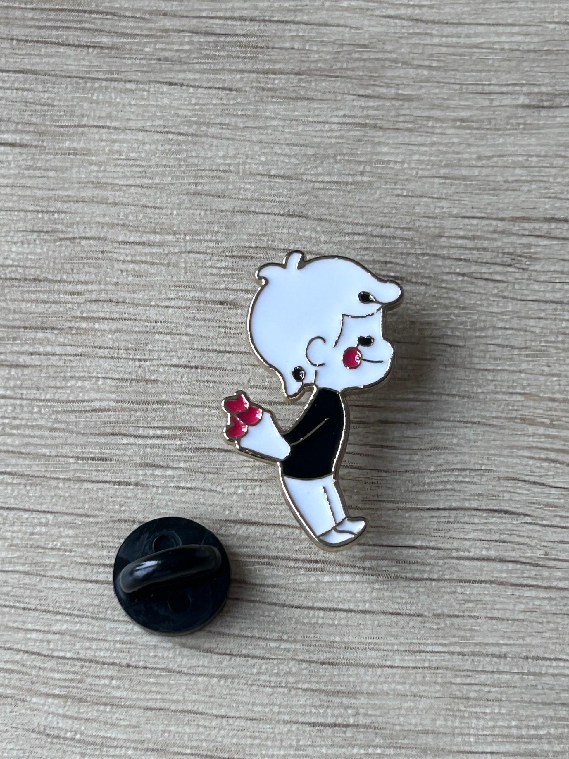 Broche émail garçon kawaii tenant un petit bouquet rouge, avec attache arrière