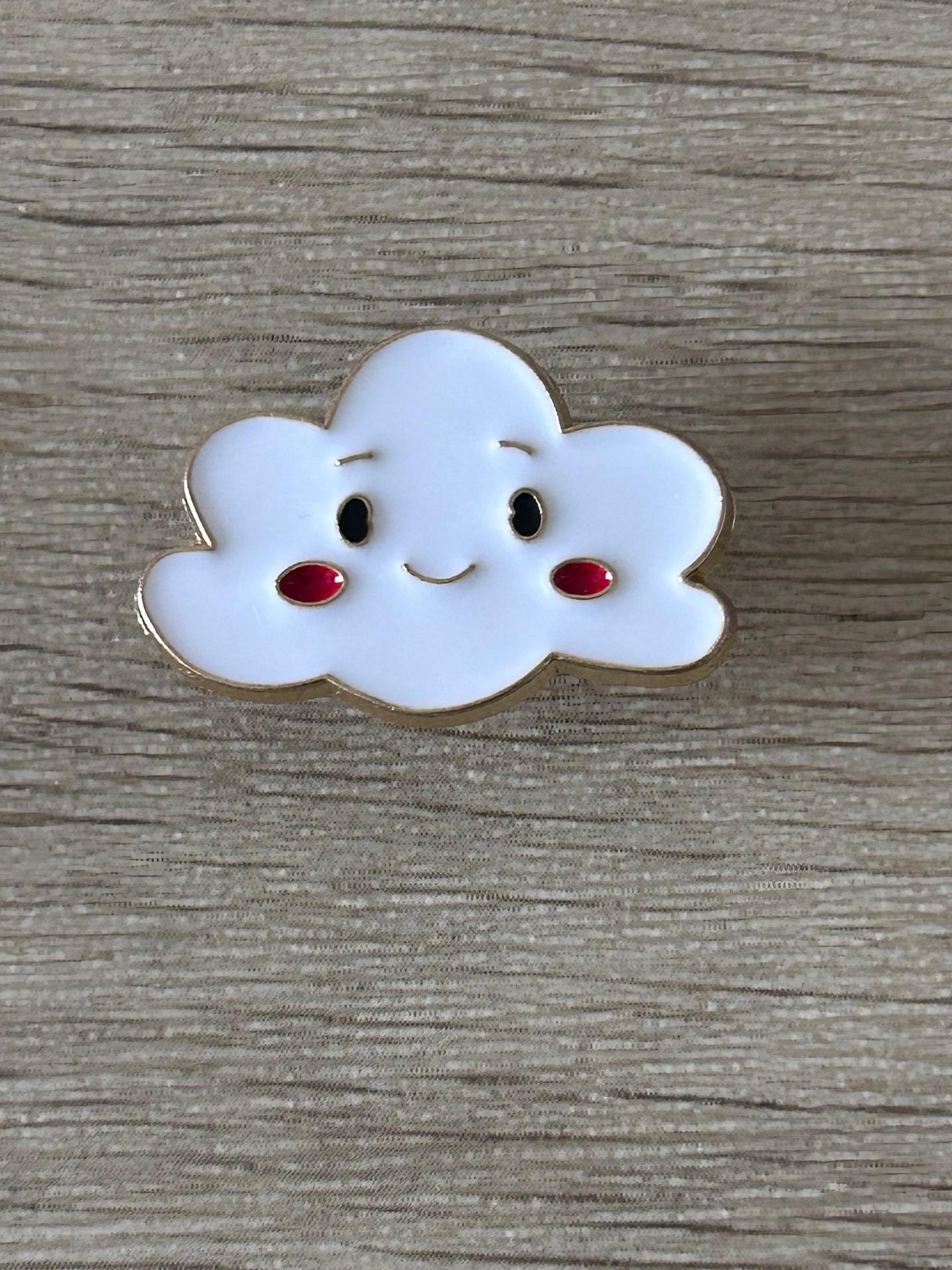 Broche en forme de nuage bleu clair souriant, yeux noirs et bouche rouge
