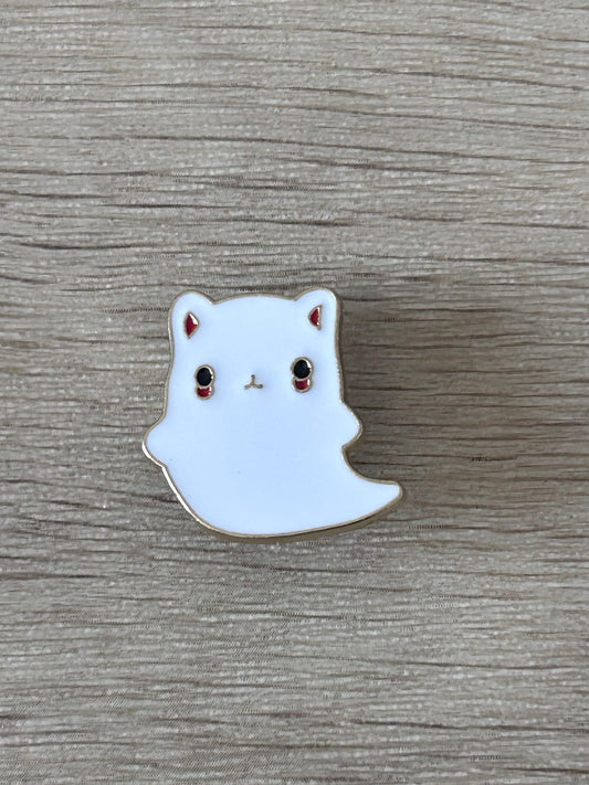Épingle chat fantôme émaillée, visage blanc avec oreilles pointues, yeux rouges, contour beige.