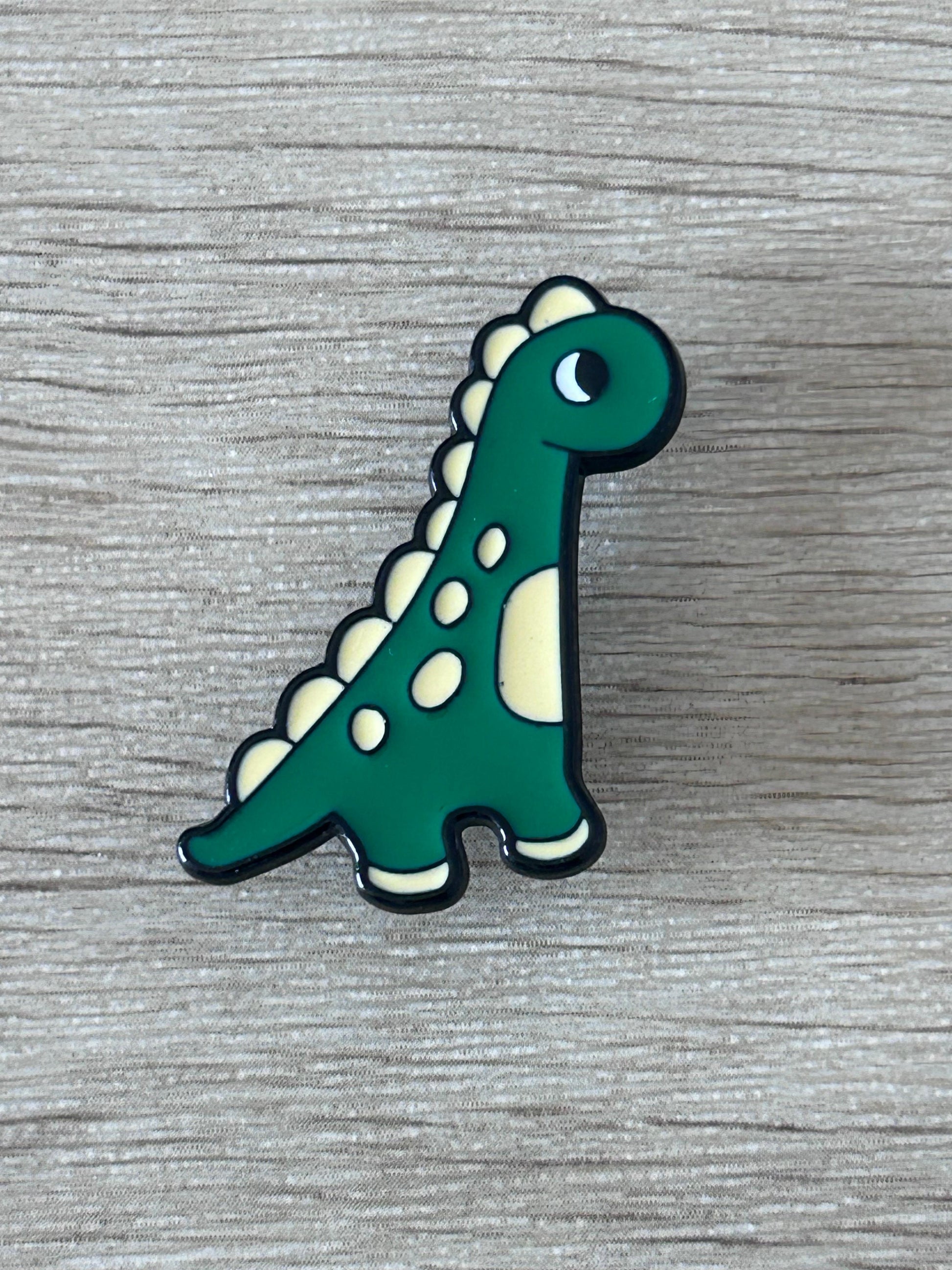Broche brontosaure kawaii en émail vert, ventre crème, points blancs