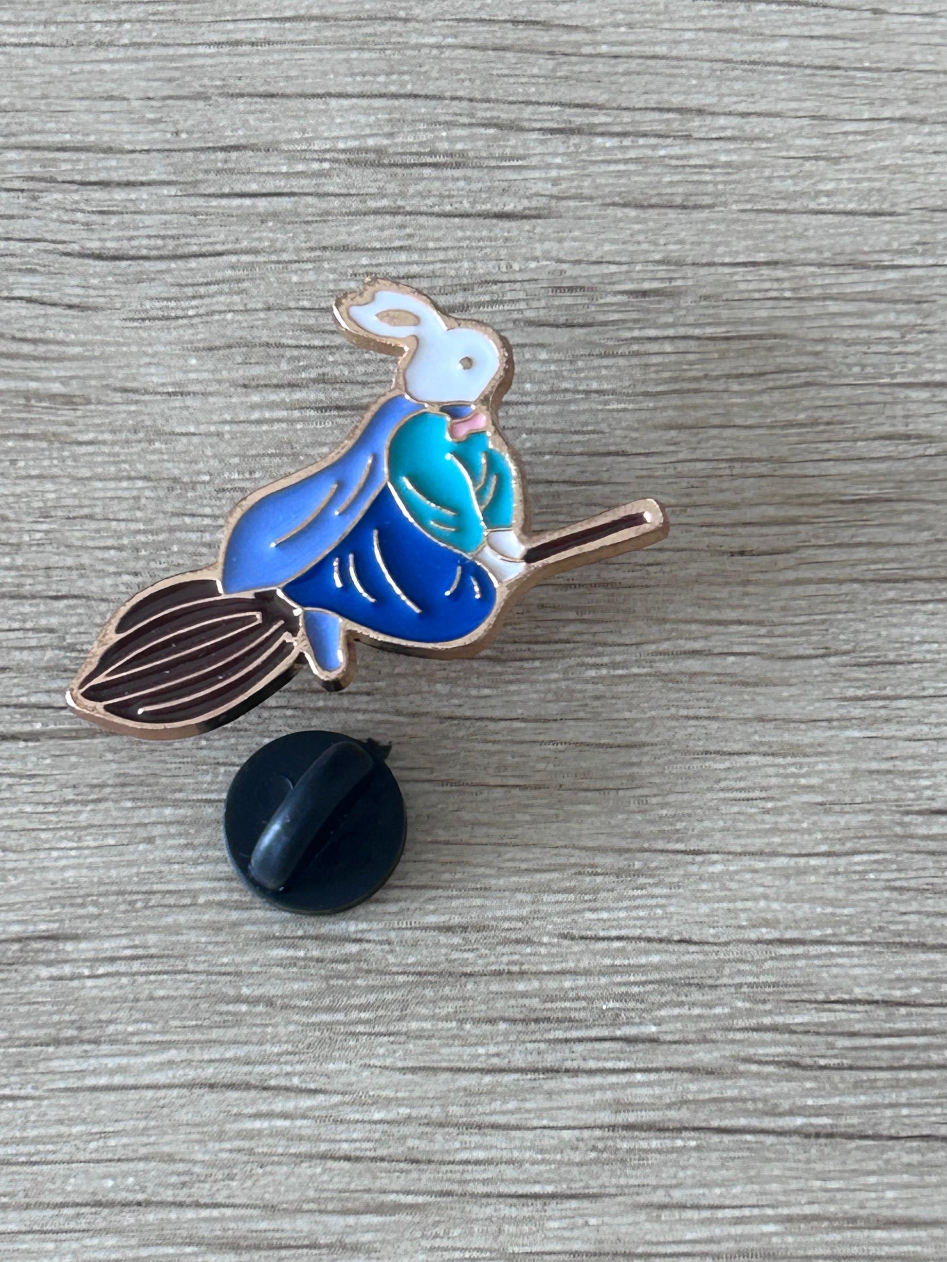 Épingle lapin sorcier bleu sur balai, avec attache noire