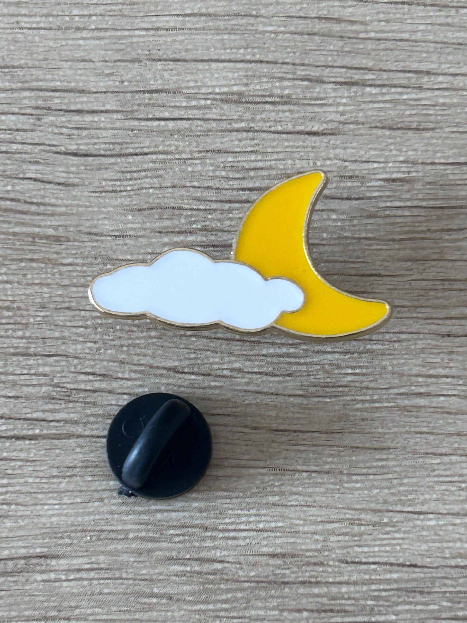 Pin nuage et lune émaillé : nuage bleu clair et lune jaune, avec support noir.